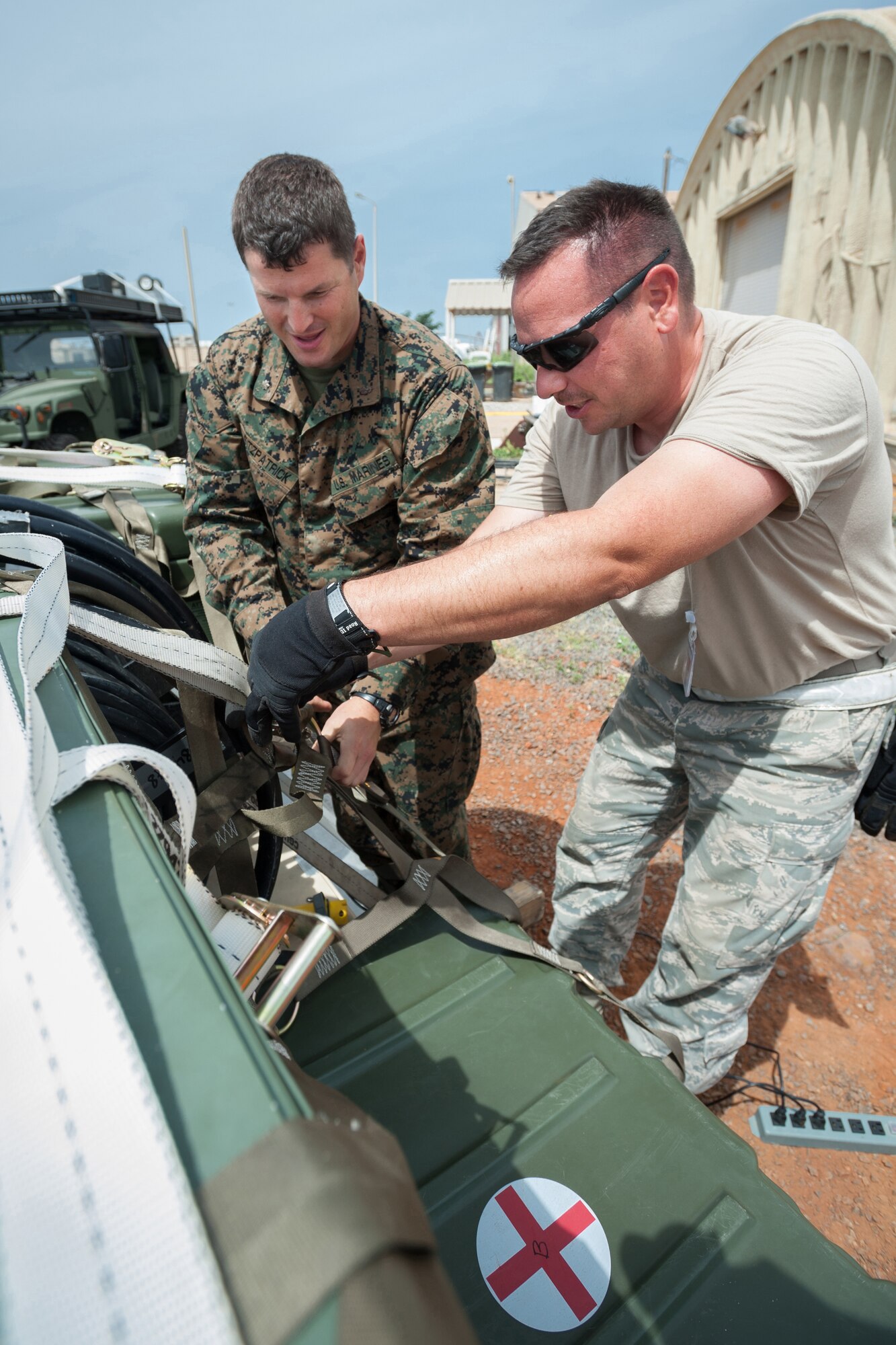 U.S. Navy Lt. Cmdr. Joseph Fitzpatrick (left), a surgeon assigned to a Forward Resuscitive Surgical System unit, and U.S. Air Force Staff Sgt. Tony Hayden, an aerial porter from the Kentucky Air National Guard’s 123rd Contingency Response Group, secure cases of red blood cells and frozen plasma to a C-130 cargo pallet at Léopold Sédar Senghor International Airport in Dakar, Senegal, Oct. 10, 2014, in support of Operation United Assistance. The medical supplies and Fitzpatrick’s unit are bound for Liberia to support Special Purpose Marine Air-Ground Task Force-Crisis Response AFRICOM. (U.S. Air National Guard photo by Maj. Dale Greer)