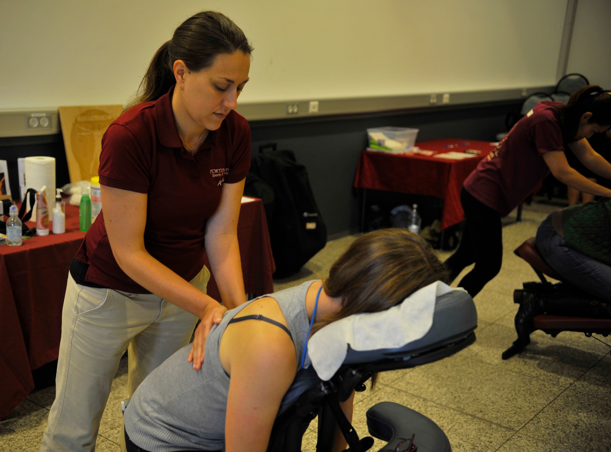 Amber Maez, Fortis Vitae Sports and Wellness massage therapist, massages a member of Team Ramstein at the Kaiserslautern Military Community Fair Oct. 17, 2014 at Ramstein Air Base, Germany. The Fortis Vitae Sports and Wellness personnel offered massages and precise weight measurements, to include muscle density and fat percentage. (U.S. Air Force photo/Airman Larissa Greatwood)