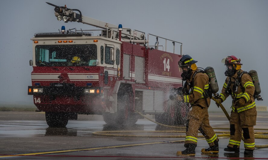 Two firefighters simulate extinguishing an aircraft fire after a simulated crash on the flightline as part of a major accident response exercise on Ramstein Air Base, Germany, Oct. 18, 2014. Members of the Air Force and host nation agencies partnered in conducting a response and recovery in preparation for possible real-world incidents. (U.S. Air Force photo/Airman 1st Class Jordan Castelan)