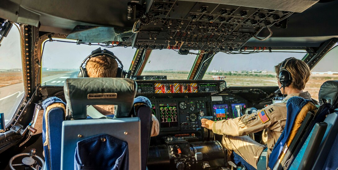 U.S. Air Force Capts. Braden Gross, left. and Jennifer Nolta, right, take off in a C-5M Super Galaxy from an undisclosed location in Southwest Asia, Oct. 6, 2014. Gross and Nolta were among airmen from the 9th Airlift Squadron who transported more than 11 million pounds of cargo in a 50-day period as part of retrograde operations in Afghanistan. 