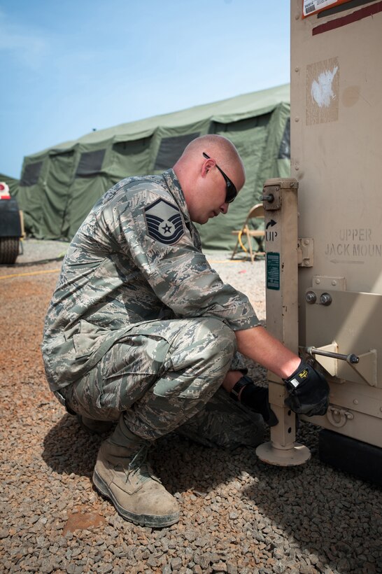 U.S. Air Force Master Sgt. Matthew Hourigan installs leveling jacks on a mobile airfield operations center at Leopold Sedar Senghor International Airport in Dakar, Senegal, Oct. 17, 2014. Hourigan is assigned to the Kentucky Air National Guard’s 123rd Contingency Response Group.