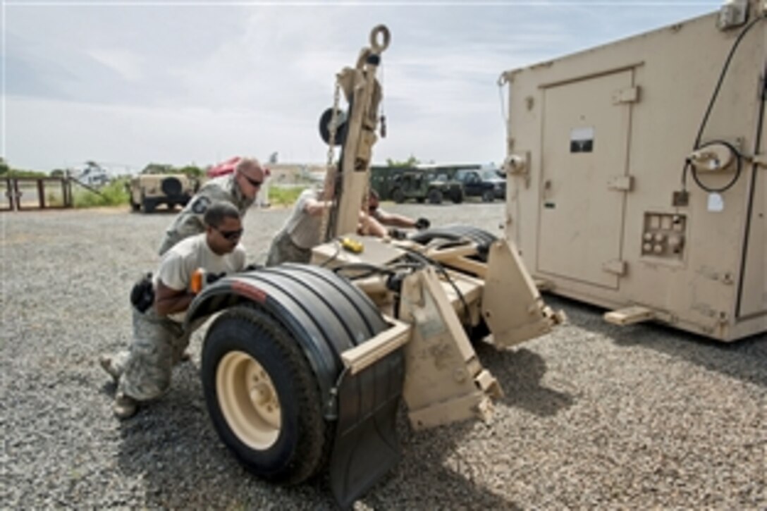 Airmen from the Kentucky Air National Guard’s 123rd Contingency Response Group remove transport wheels from a mobile airfield operations center at Leopold Sedar Senghor International Airport in Dakar, Senegal, Oct. 17, 2014, to support Operation United Assistance. The airmen are operating a staging base to funnel humanitarian aid and military support equipment into affected areas to respond to the Ebola outbreat in West Africa.