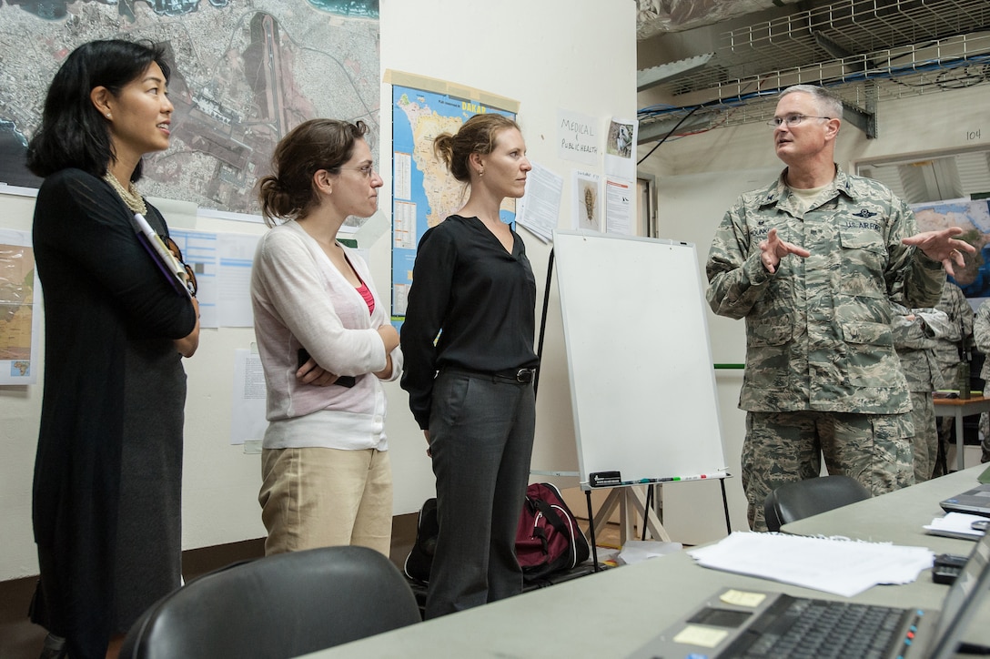 Colonel David Mounkes, USAF, commander of Joint Task Force–Port Opening Senegal, discusses unit’s mission as part of Operation United Assistance with delegation representing U.S. Agency for International Development, at Léopold Sédar Senghor International Airport, in Dakar, Senegal, October 16, 2014 (U.S. Air National Guard/Dale Greer)