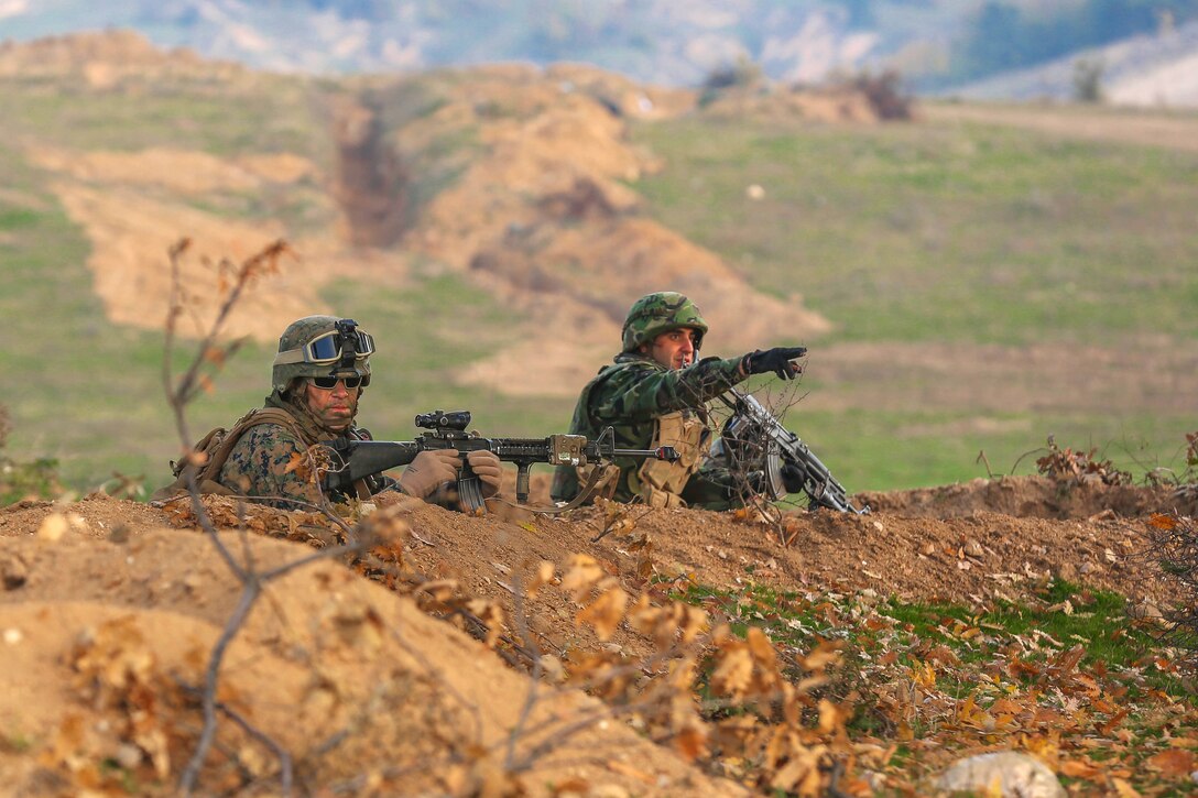 A U.S. Marine and Bulgarian soldier prepare for an enemy attack during Exercise Strike Back, Oct. 15 at the Koren Field Training Ground, Bulgaria. Strike Back is a multilateral combat exercise designed to prepare Bulgarian forces to control, command and operate with joint-nation forces. The training consisted of defensive tactics and offensive objectives and maneuvers.