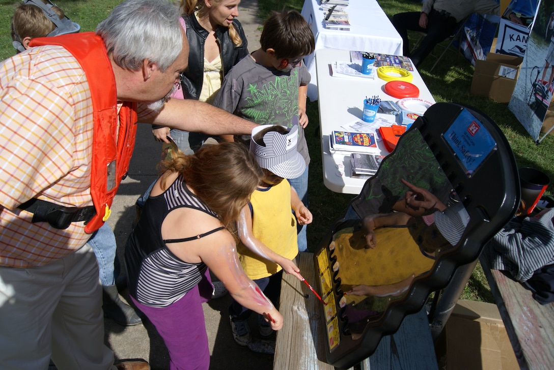 Eugene Goff, manager, Kansas Area Office of the Tulsa District U.S. Army Corps of Engineers, points out the available prizes after a little zombie correctly answers a water safety question during the annual Caney Zombie Walk in Caney, Kansas, Oct. 18.