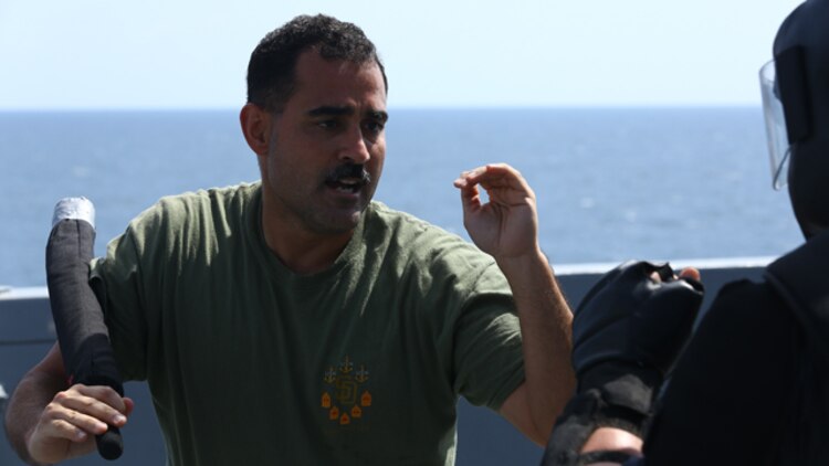U.S. Navy Hospital Corpsman Chief Petty Officer Juan J. Rivera with Combat Logistics Battalion 11, 11th Marine Expeditionary Unit (MEU) and native of Brooklyn, New York, uses a baton to subdue a simulated protestor during an Oleoresin Capsicum (OC) spray, also known as pepper spray, and nonlethal weapons qualification course aboard the USS San Diego (LPD 22), Oct. 10. The 11th MEU is a forward-deployed, flexible sea-based Marine Air-Ground Task Force embarked with the Makin Island Amphibious Ready Group in the U.S. 5th Fleet area of responsibility. (U.S. Marine Corps photo by Cpl. Jonathan R. Waldman/Released)