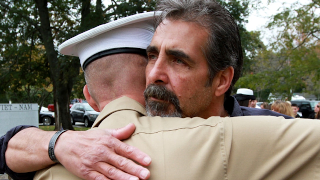 Mark Vasselian embraces Maj. James Nolan, Inspector-Instructor for Headquarters and Service Company and Weapons Company, 1st Battalion, 25th Marine Regiment, following a ceremony where his son, Sgt. Daniel Vasselian, was posthumously awarded the Bronze Star Medal with Combat Distinguishing Device, Oct. 13, in front of the American Legion’s Lewis V. Dorsey Post 112 War Memorial in Abington, Mass. Daniel was posthumously awarded the Bronze Star Medal with Combat Distinguishing Device for combat actions while on his third deployment to Afghanistan. Daniel’s wife, Erin Vasselian, and parents, Karen and Mark Vasselian, each were presented with medals during the ceremony. Daniel was killed in action Dec. 23, 2013 in Helmand Province, Afghanistan. (Photo by Sgt. Richard Blumenstein)