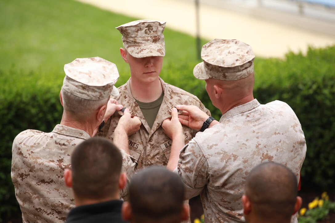 Gen. James F. Amos, the 35th Commandant of the Marine Corps, and Sgt. Maj. Micheal P. Barrett, the 17th Sergeant Major of the Marine Corps, promote Sgt. Michael Haynes to his current grade at Marine Barracks Washington, D.C., on Oct. 16, 2014. (U.S. Marin