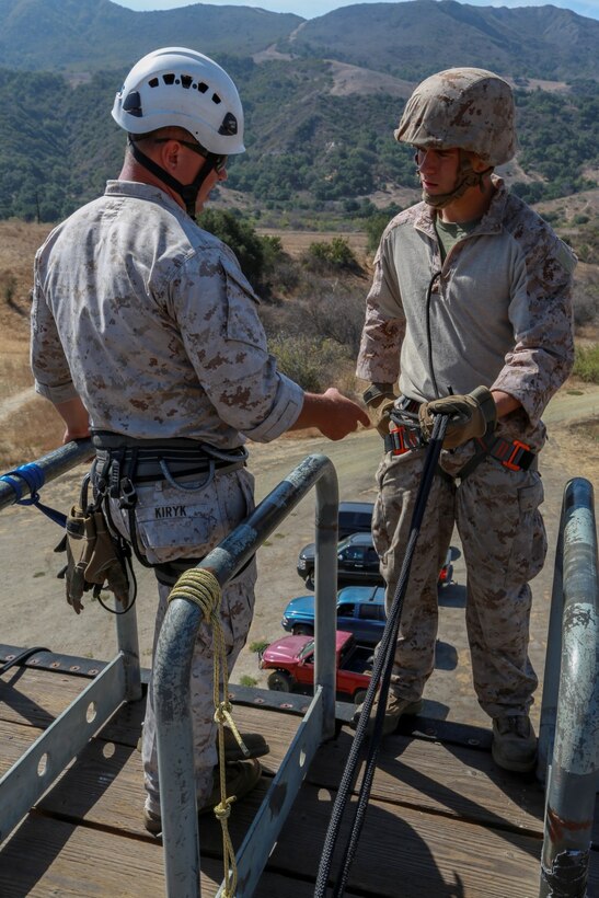 U.S. Marine Cpl. Brian Mullins, right, prepares to rappel while Cpl. Nicholas Kiryk inspects his harness during a helicopter rope-suspension techniques masters course aboard Camp Pendleton, Calif., Oct. 14, 2014. Kiryk is an instructor with Special Operations Training Group, I Marine Expeditionary Force.  Mullins is a parachute rigger with Battalion Landing Team, 3rd Battalion, 1st Marines, 15th Marine Expeditionary Unit. BLT 3/1 is deploying this spring as the 15th MEU’s ground combat element. (U.S. Marine Corps photo by Cpl. Steve H. Lopez/Released)