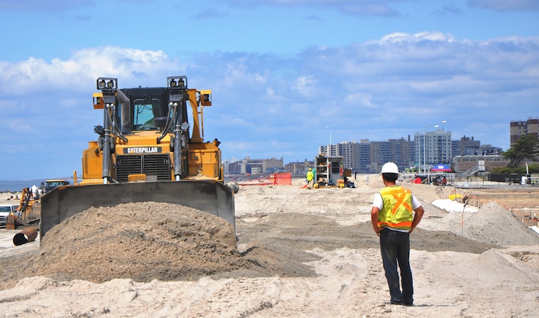 A bulldozer levels freshly-deposited sand on Rockaway Beach, Queens, New York, on June 26, 2014. The work is part of a $36.5 million coastline restoration project placing nearly 3.5 million cubic yards of sand repairing severe erosion from Hurricane Sandy and reducing coastal storm risks. Click here for more info on the Rockaway project. (photo by James D’Ambrosio, New York District Public Affairs)