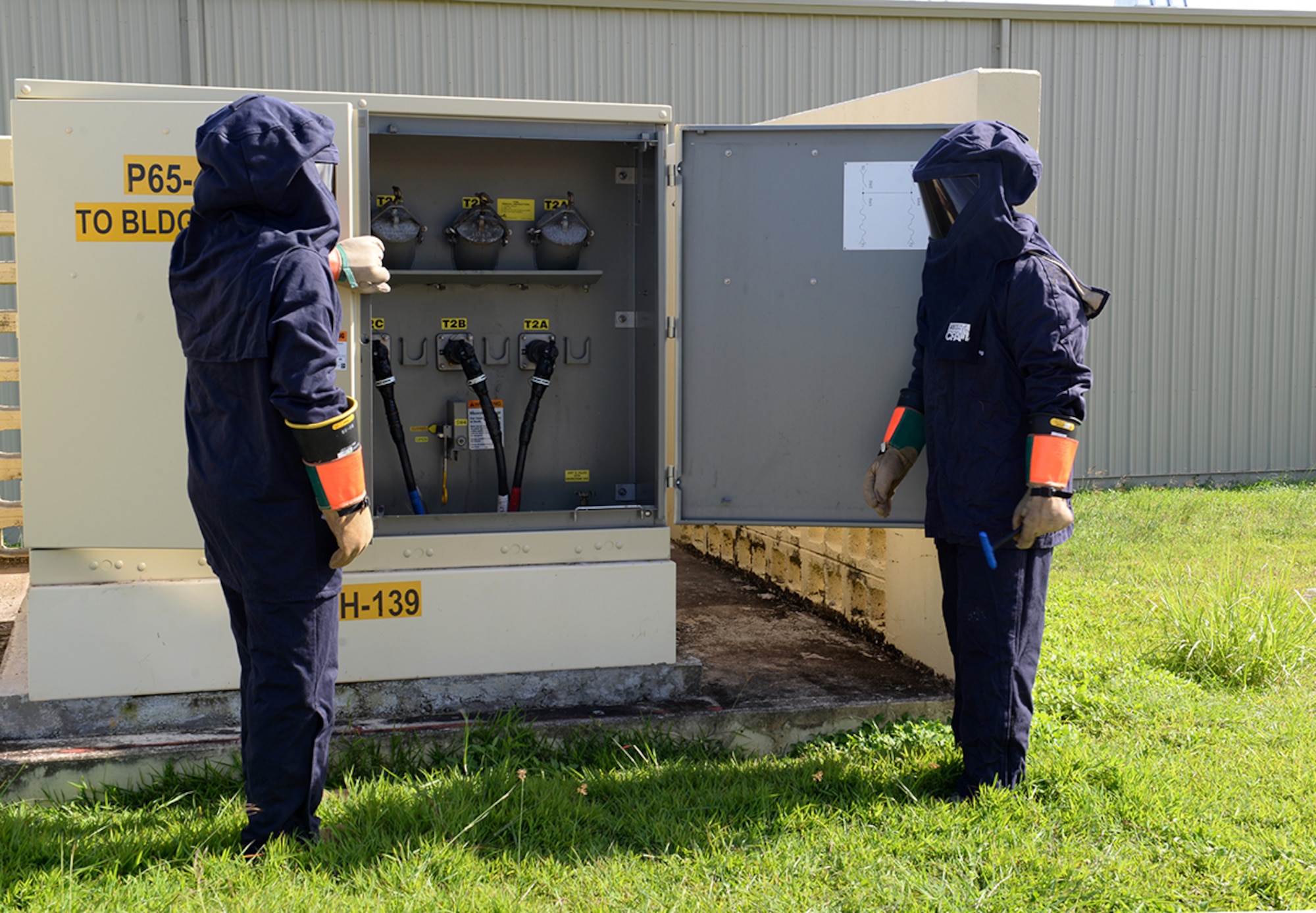 Airman 1st Class Enrique Flores, 36th Civil Engineer Squadron electrical systems apprentice and Staff Sgt. Welmer Reyes, 36th CES electrical systems craftsman, open a high voltage switch Oct. 21, 2014, on Andersen Air Force Base, Guam. Andersen Airmen and civilian contractors work constantly to provide power to base workers and residents. (U.S. Air Force photo by Airman 1st Class Amanda Morris/Released)