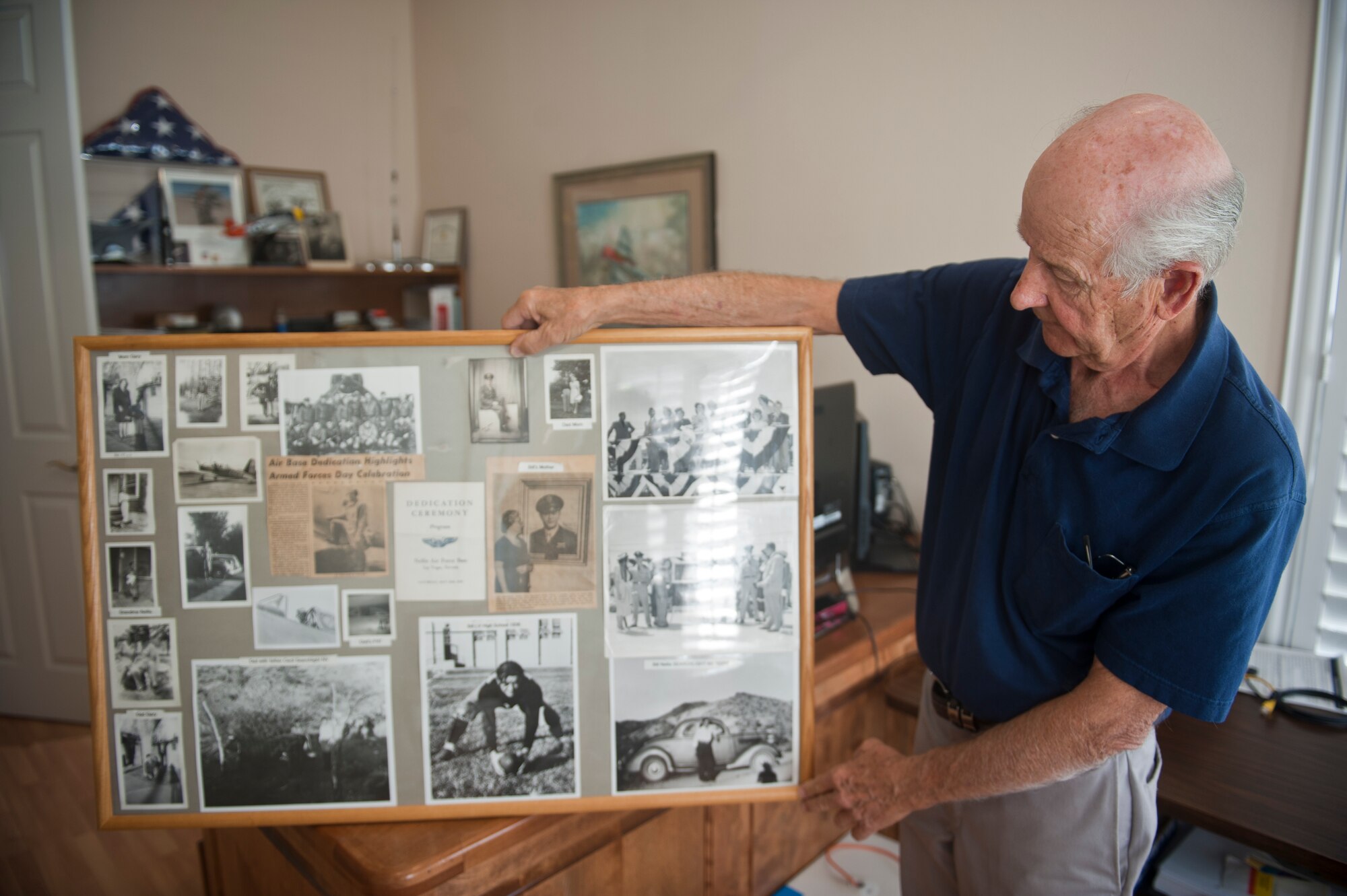 Gary Nellis, son of the late 1st Lt. William Harrell Nellis, Nellis Air Force Base’s namesake, displays a picture board of his father at his home in Henderson, Nev., Oct. 6, 2014. William Nellis’ P-47 Thunderbolt was shot down while strafing a German convoy over Luxembourg during the Battle of the Bulge on Dec. 27, 1944. Although the lieutenant had been shot down twice during his previous 68 World War II missions and survived, he would not make it a third time. (U.S. Air Force photo by Staff Sgt. Siuta B. Ika)