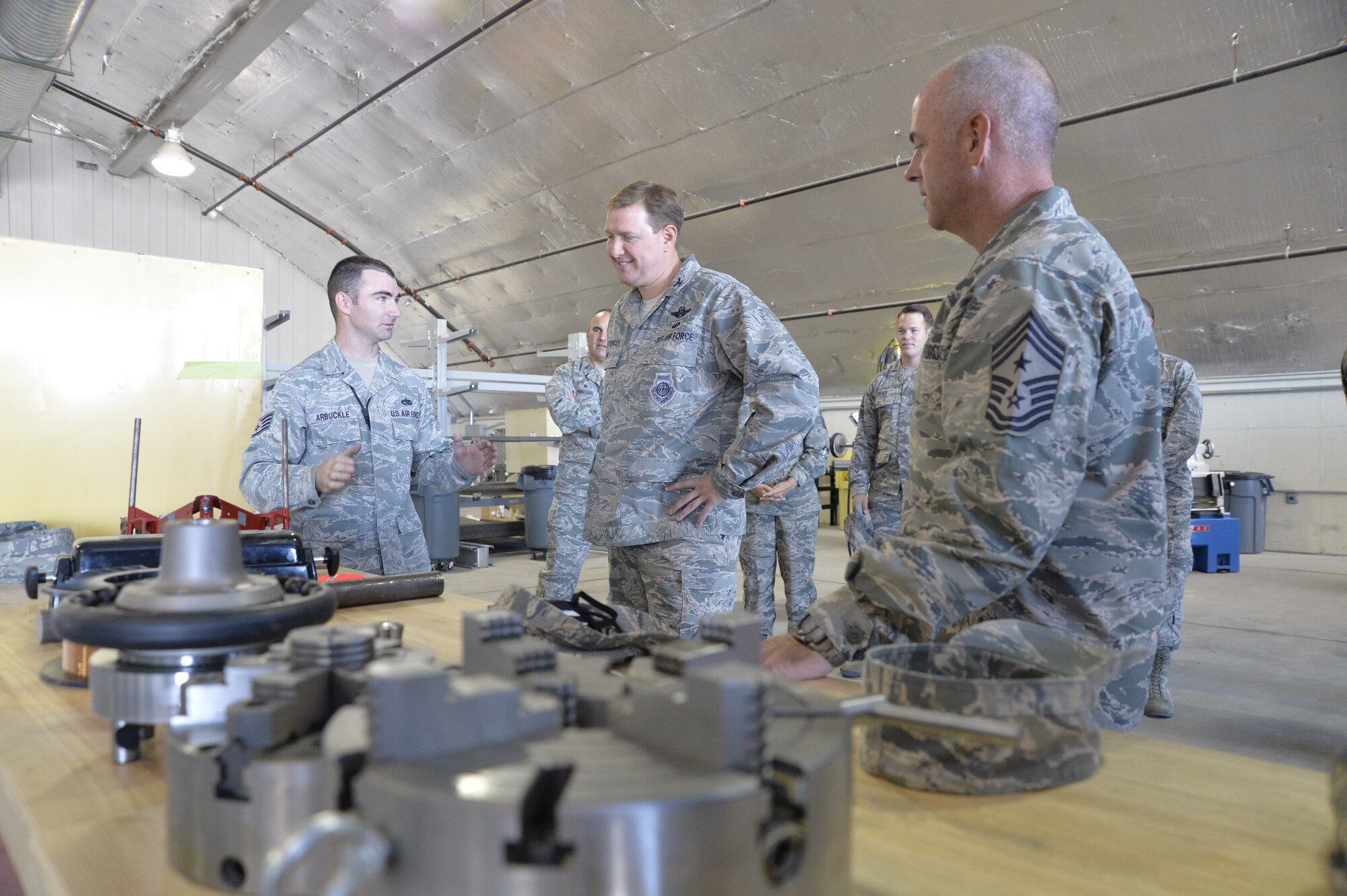 Staff Sgt. Zachary Arbuckle, 432nd Maintenance Squadron Aircraft Metals Technology Section chief, left, briefs 432nd Wing/432nd Air Expeditionary Wing leadership during a “ribbon” cutting ceremony Oct. 9, 2014, at Creech Air Force Base, Nevada. The section’s new facility is the first of its kind here and has the capability to manufacture parts and tools for aircraft and different units around base. (U.S. Air Force photo by Staff Sgt. Adawn Kelsey/released)