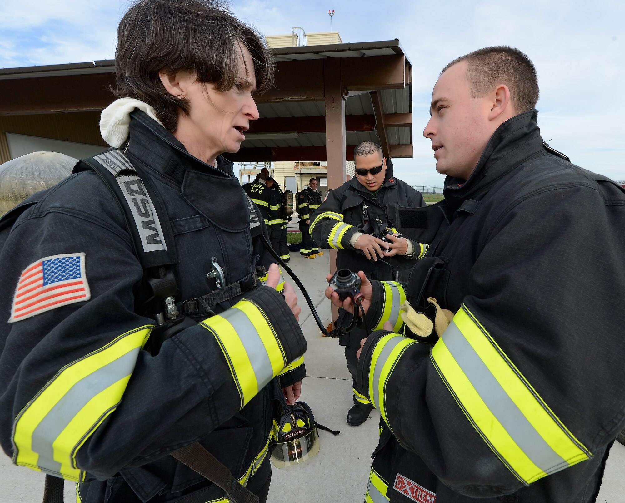 Col. Lisa Pike, 436th Mission Support Group commander, left, receives instruction on how to properly use firefighting equipment from Senior Airman Matthew Johnson, 436th Civil Engineer Squadron firefighter, prior to a structural fire training event Oct. 20, 2014, at Dover Air Force Base, Del. Pike and other senior leaders learned about the challenges faced by fire fighters by completing the training. (U.S. Air Force photo/Greg L. Davis)