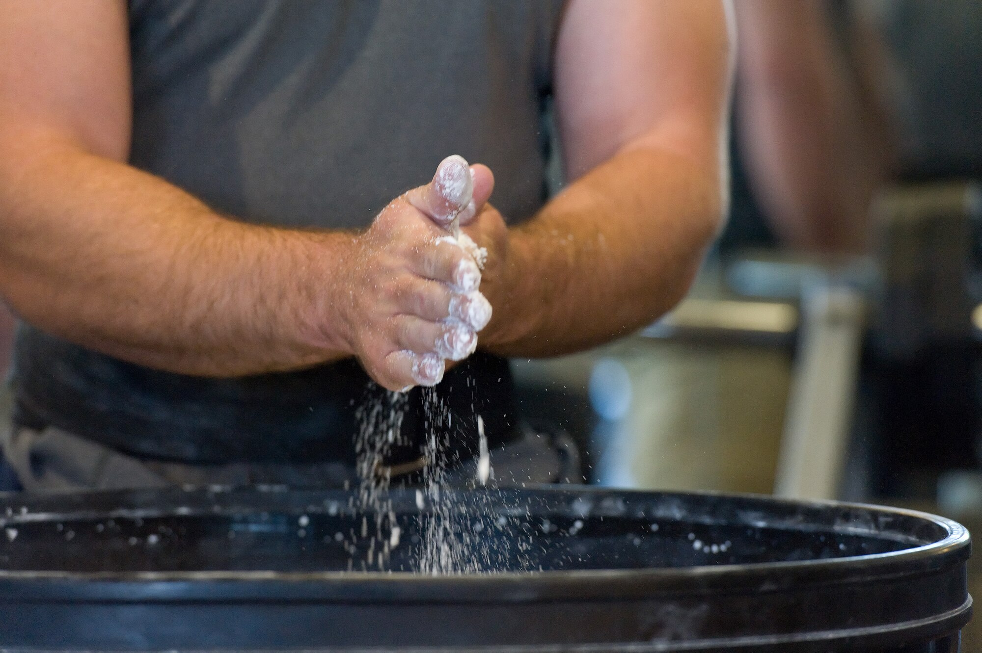 John Walters Jr. chalks his hands prior to one of his three bench press attempts Oct. 17, 2014, at the Fitness Center on Dover AFB, Del. Walters was one of 15 male and female powerlifters entered in the 2014 Dover Air Force Base Powerlifting Competition and was named the overall winner of the competition. (U.S. Air Force photo/Roland Balik)
