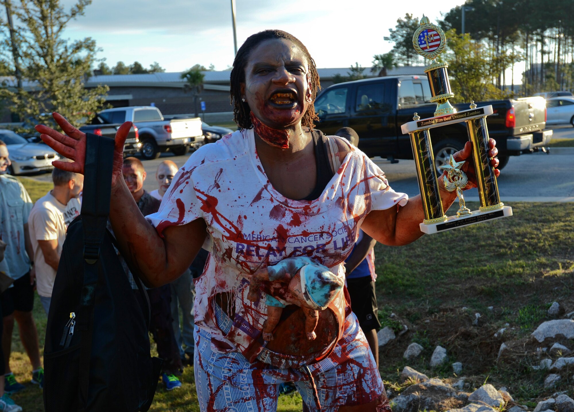 U.S. Air Force Staff Sgt. Vinetra Gilbert, 20th Maintenance Group assistant engine manager, holds her trophy for 1st place best-dressed zombie during the Zombie 5K at Shaw Air Force Base, S.C., Oct. 16, 2014. The 5K was put on by the Air Force Sergeants Association Chapter 377. (U.S. Air Force photo by Senior Airman Tabatha Zarrella/Released)
