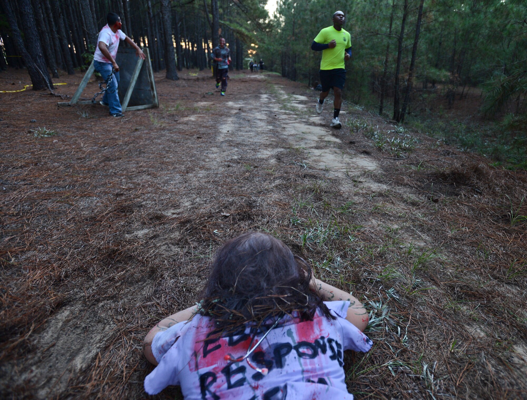 A zombie lays on a trail while waiting for runners to pass during a Zombie 5K at Shaw Air Force Base, S.C., Oct. 16, 2014. Simulated zombies were scattered throughout the trail and among the runners. (U.S. Air Force photo by Senior Airman Tabatha Zarrella/Released)