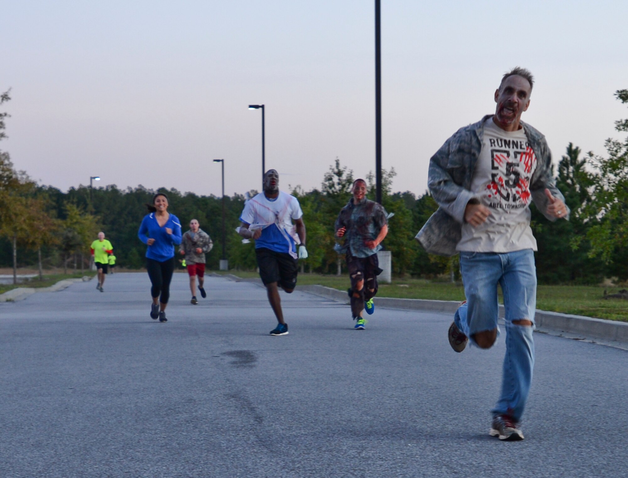 Airmen dressed as zombies run with participants during the Zombie 5K at Shaw Air Force Base, S.C., Oct. 16, 2014. During the 5K, zombies attempted to retrieve participants’ flags, which would win them prizes at the end of the run. (U.S. Air Force photo by Senior Airman Tabatha Zarrella/Released)