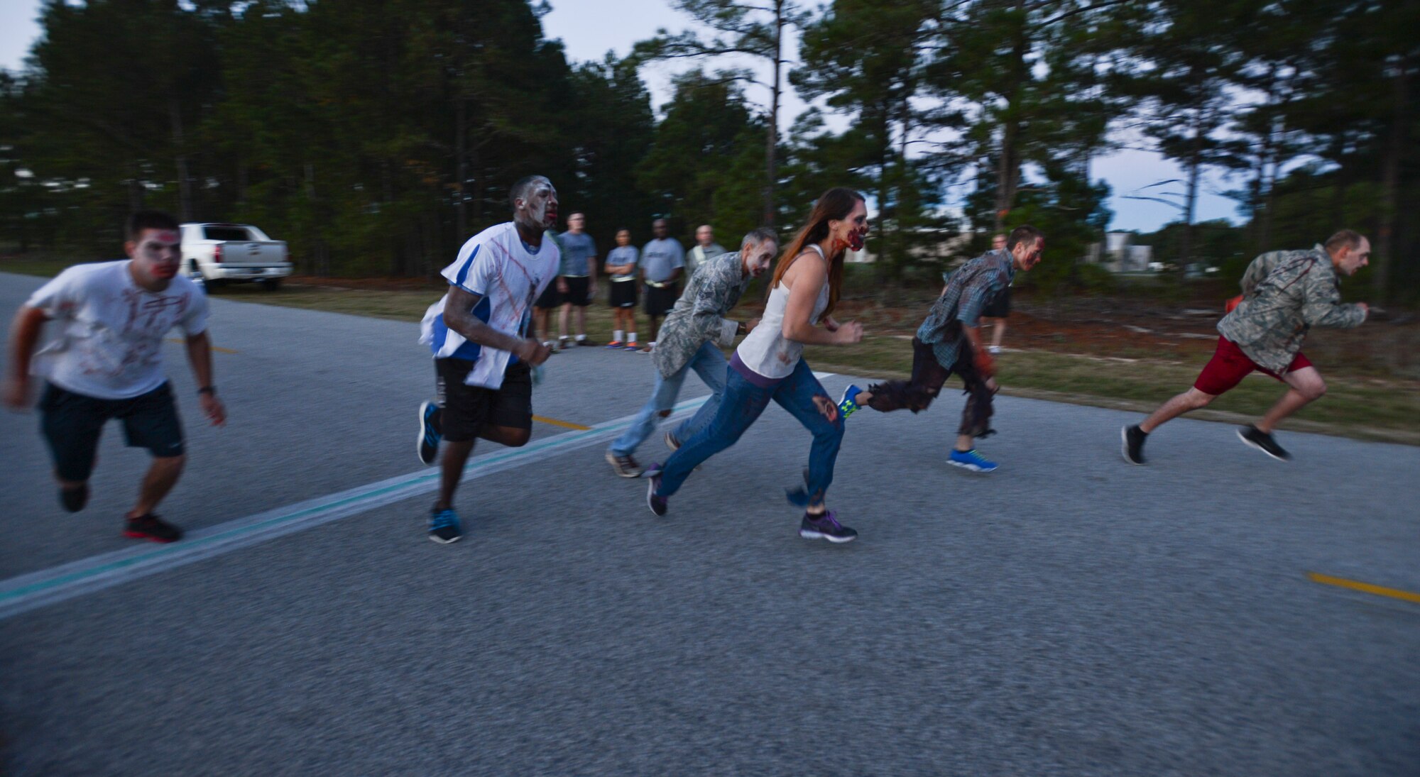 Team Shaw members dressed as zombies begin the 5K competitive run at Shaw Air Force Base, S.C., Oct. 16, 2014. The Air Force Sergeants Association Chapter 377 held the Zombie 5K, which consisted of two groups of runners, competitive and non-competitive. (U.S. Air Force photo by Senior Airman Tabatha Zarrella/Released)
