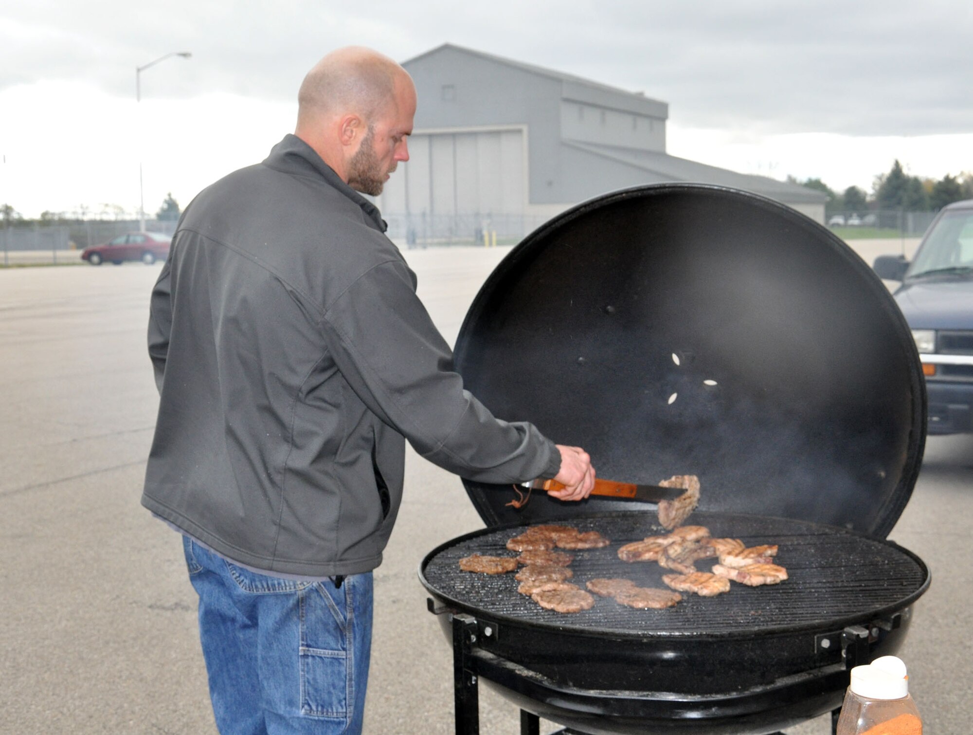 WRIGHT-PATTERSON AIR FORCE BASE, Ohio – Staff Sgt. Eric Whiteaker, 445th Maintenance Squadron Fabrication Flight metals technology journeyman, flips pork chops on the grill during the 445th Maintenance Group burger burn Oct. 21, 2014. The burger burn was held to help celebrate the maintainers closing out FY14 with an above average mission capable rate for the wing's fleet of nine C-17 Globemaster IIIs. (U.S. Air Force photo/Stacy Vaughn)