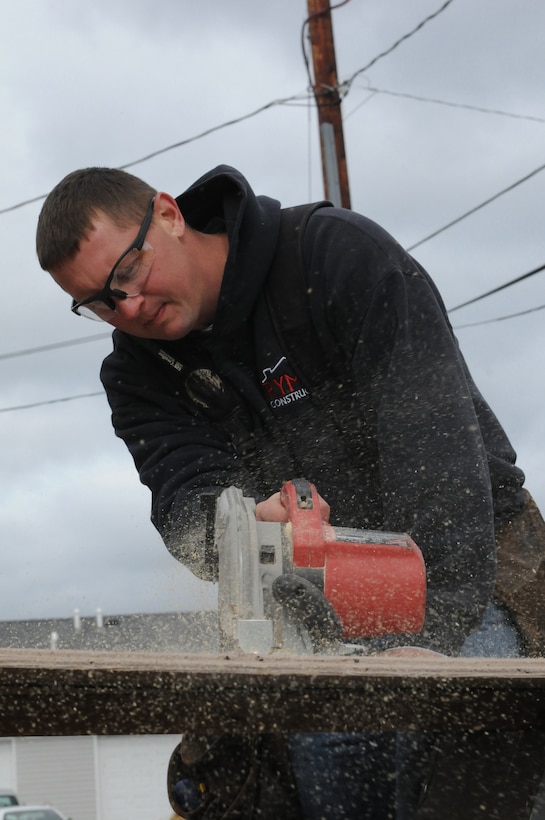 An airmen with the 148th Fighter Wing uses a skill saw to cut plywood during construction Oct. 4, 2014.  Duluth based members of the Minnesota Air National Guard volunteered for their third straight year, working with Habitat for Humanity on community construction projects.  (U.S. Air National Guard photo by Tech. Sgt. Amie M. Muller)