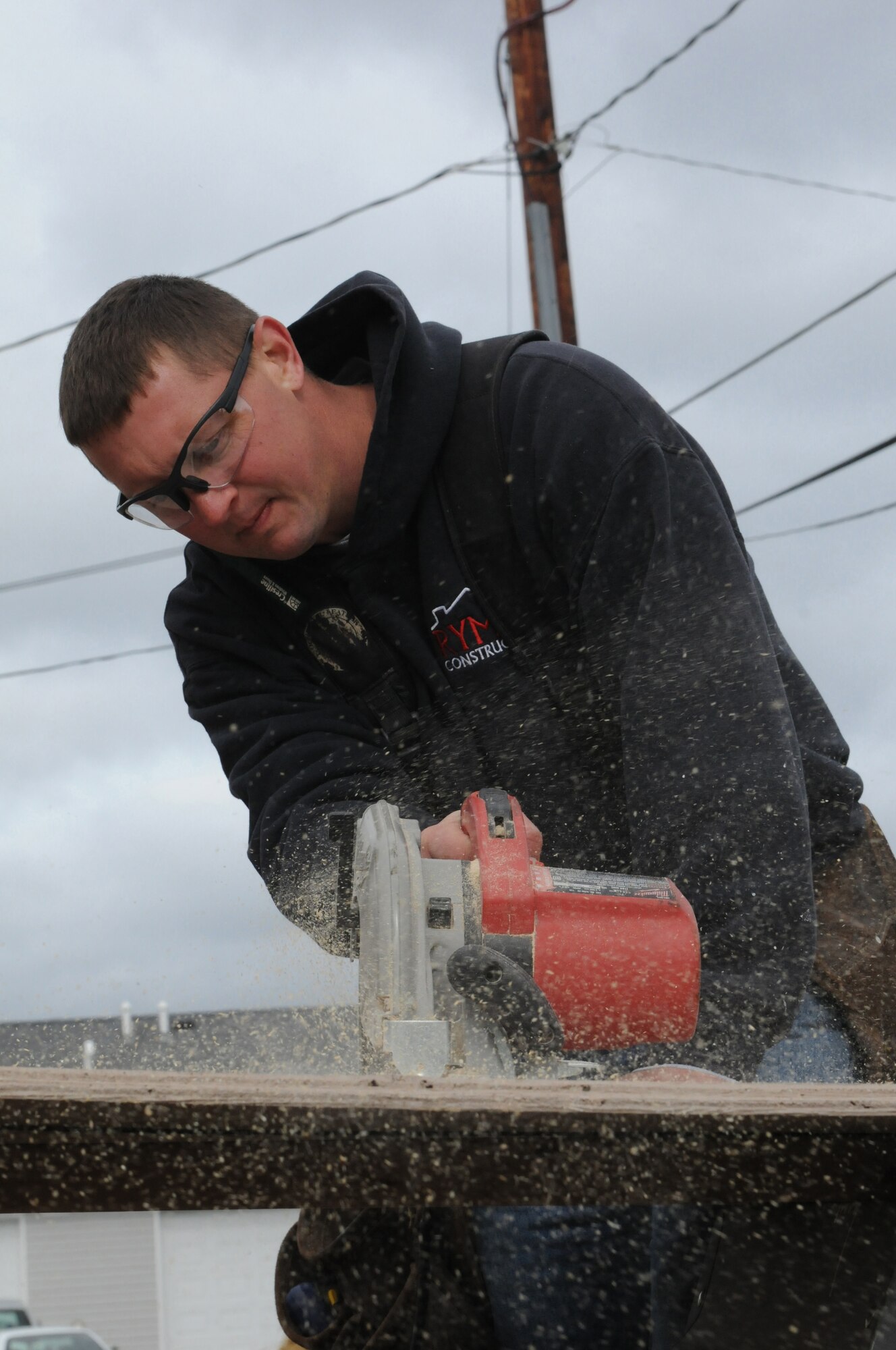 An airmen with the 148th Fighter Wing uses a skill saw to cut plywood during construction Oct. 4, 2014.  Duluth based members of the Minnesota Air National Guard volunteered for their third straight year, working with Habitat for Humanity on community construction projects.  (U.S. Air National Guard photo by Tech. Sgt. Amie M. Muller)