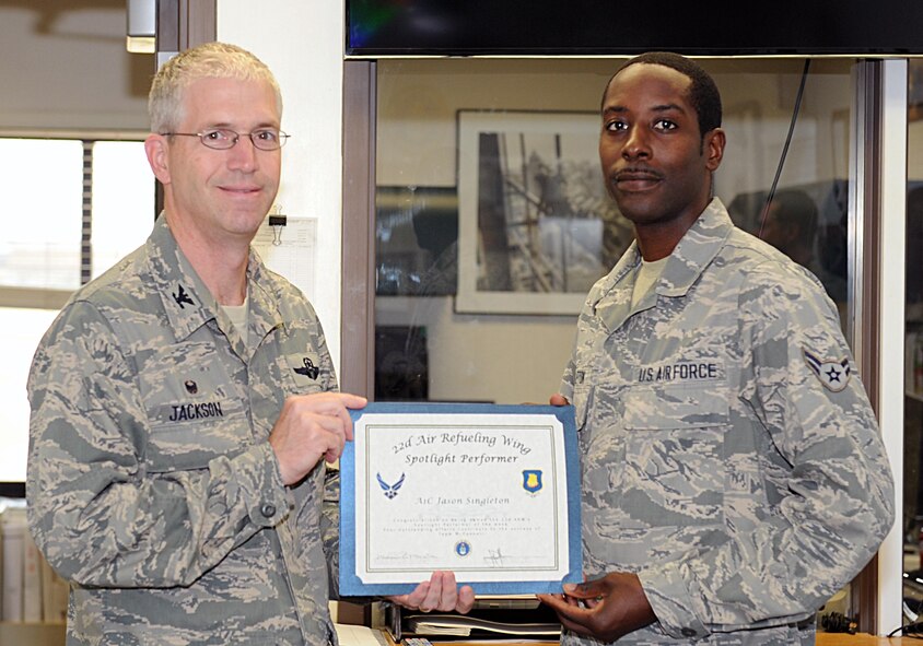 Col. Joel Jackson, 22nd Air Refueling Wing commander, poses with Airman 1st Class Jason Singleton, 22nd Civil Engineer Squadron water and fuel systems maintenance apprentice, Oct. 21, 2014, at McConnell Air Force Base, Kan. Singleton was selected as the spotlight performer for the week of Sept. 29 through Oct. 4. (U.S. Air Force photo/Airman 1st Class David Bernal Del Agua)