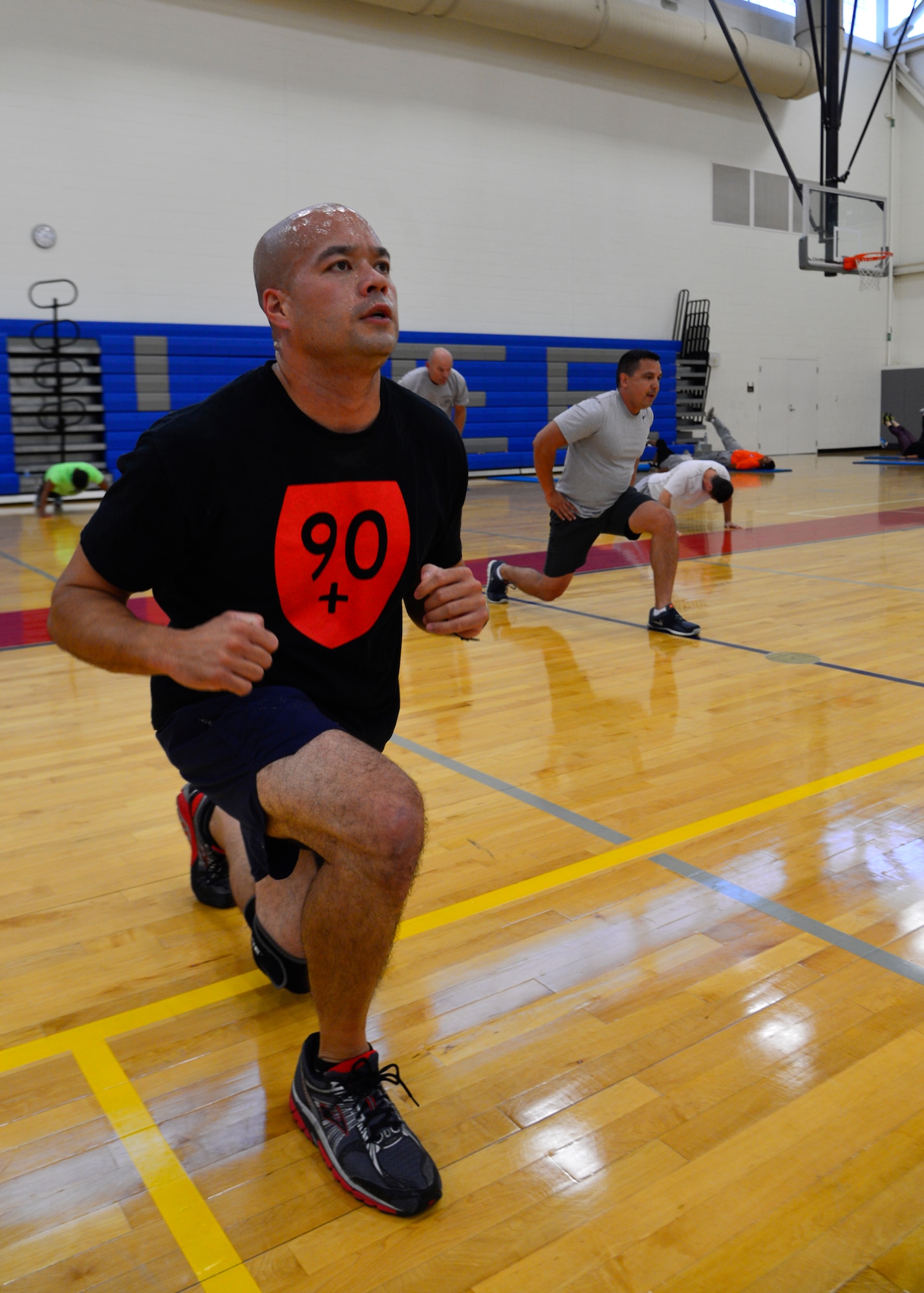 Tech. Sgt. Scott Hautanen, 436th Force Support Squadron NCO in-charge of Honor Guard, performs lunges during a “90+”workout Oct. 15, 2014, at the Fitness Center on Dover Air Force Base, Del. Hautanen received his “90+” shirt after scoring above a 90 on his fitness assessment and has participated in the “90n90” and “90+” program since Jan. 2012. (U.S. Air Force photo/Airman 1st Class William Johnson)