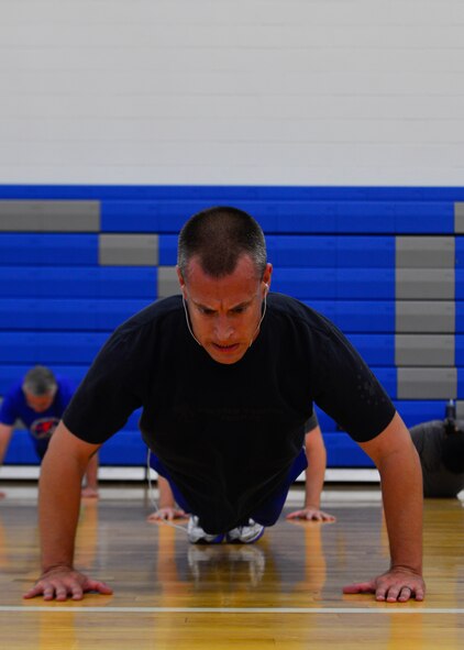 Master Sgt. Corey Diluzio, 736th Aircraft Maintenance Squadron shift chief, performs push-ups during a “90+” workout Oct. 15, 2014, at the Fitness Center on Dover Air Force Base, Del. The “90+” program replaced the “90n90” program and has more than 100 active participants. (U.S. Air Force photo/Airman 1st Class William Johnson)