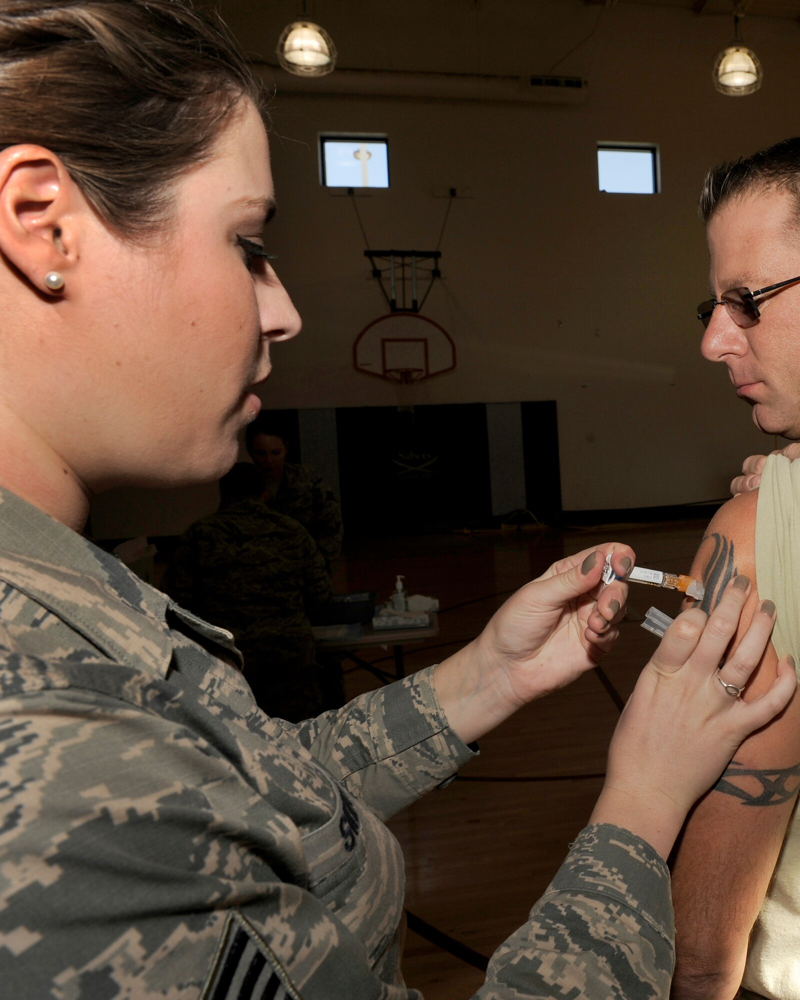 PETERSON AIR FORCE BASE, Colo. – Staff Sgt. Kayla Swift, 21st Medical Operations Squadron allergy immunization technician, administers a flu shot during the flu vaccination line at the RP Lee Youth Center Oct. 16. The 21st Medical Group set up the flu vaccination line for the day to accommodate all Team Pete employees and families needing their annual flu shot. Airmen and their families can get either the mist or the shot at the immunization clinic to help protect them against getting sick this flu season. (U.S. Air Force photo/Airman 1st Class Rose Gudex)