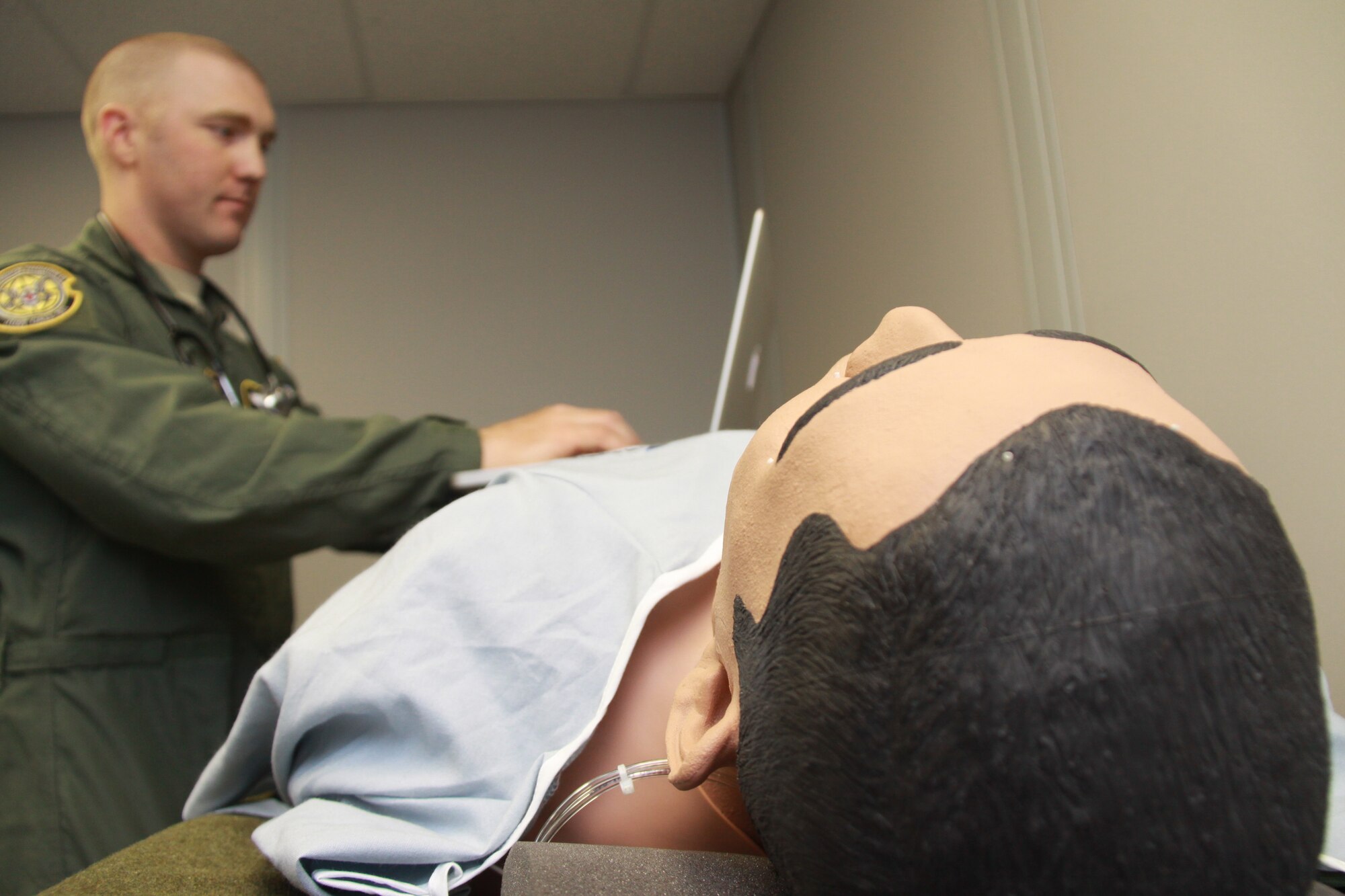 Tech. Sgt. Cole Anderson begins a vital signs test on iStan, the patient simulator, Oct. 5, 2014, at the Pittsburgh International Airport Air Reserve Station. For an aeromedical evacuation technician such as Anderson, iStan serves as an important training tool to practice inflight patient care. This patient simulator can produce sweat from sweat-like glands, “bleed” from certain parts of the body, and even get a swollen tongue. (U.S. Air Force photo by Senior Airman Justyne Obeldobel)