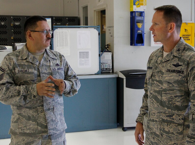 PETERSON AIR FORCE BASE, Colo. Senior Master Sgt. Freddie Sanchez, left, speaks with 22nd Air Force Vice Commander Col. Louis Patriquin during his visit to the 302nd Airlift Wing Oct. 4, 2014. Patriquin toured the maintenance shops, attended a mission brief and met with members of enlisted organizations during his one-day tour of the Reserve wing. Sanchez is the 302nd Maintenance Squadron propulsion flight chief. (U.S. Air Force photo/Staff Sgt. Nathan Federico) 