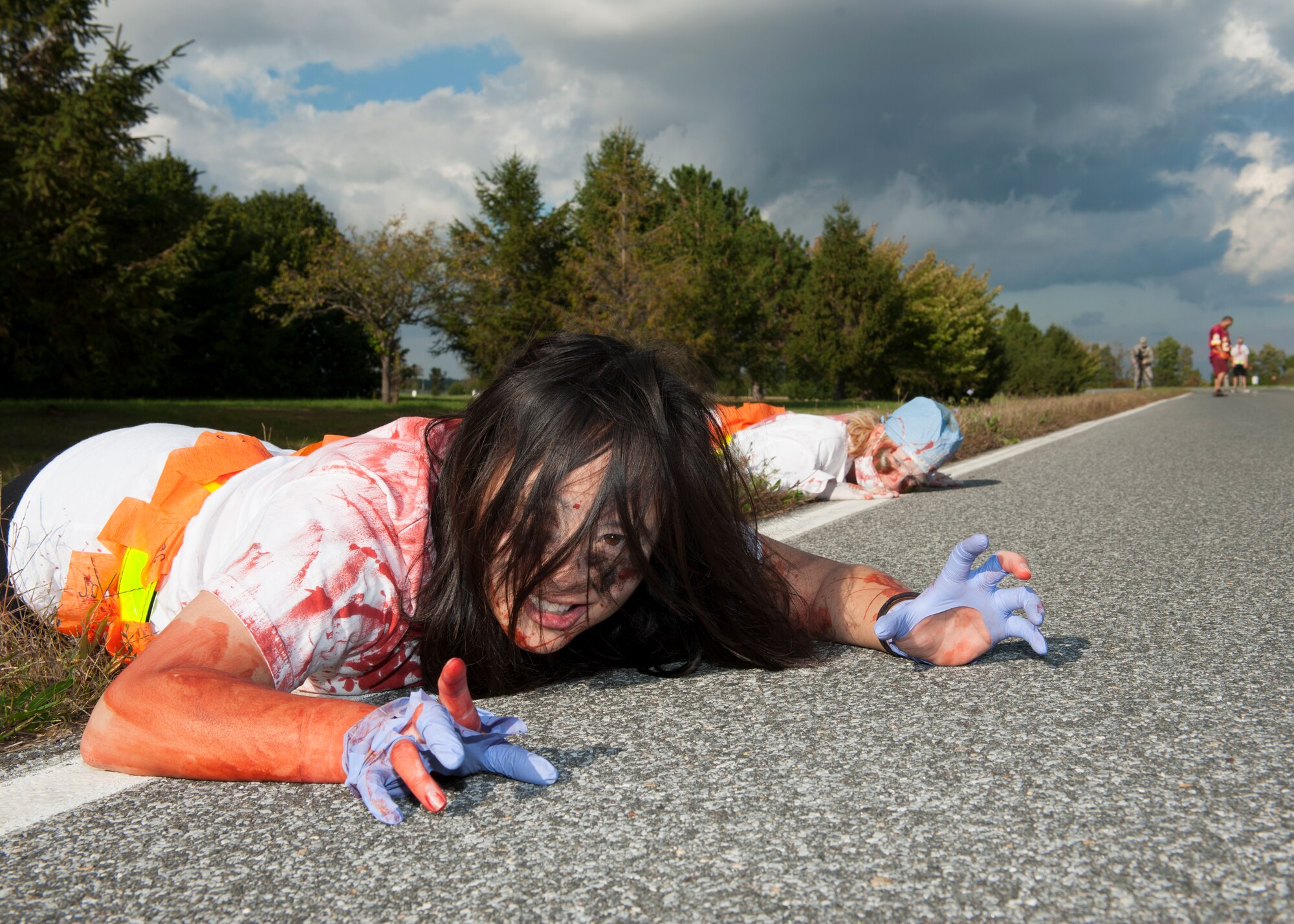 Capt. Rose Tran, 436th Dental Squadron, crawls towards runners during the Zombies of Dover race Oct. 16, 2014, at Dover Air Force Base, Del. More than $1,000 was raised for the upcoming Annual Awards Banquet. (U.S. Air Force photo/Airman 1st Class Zachary Cacicia)