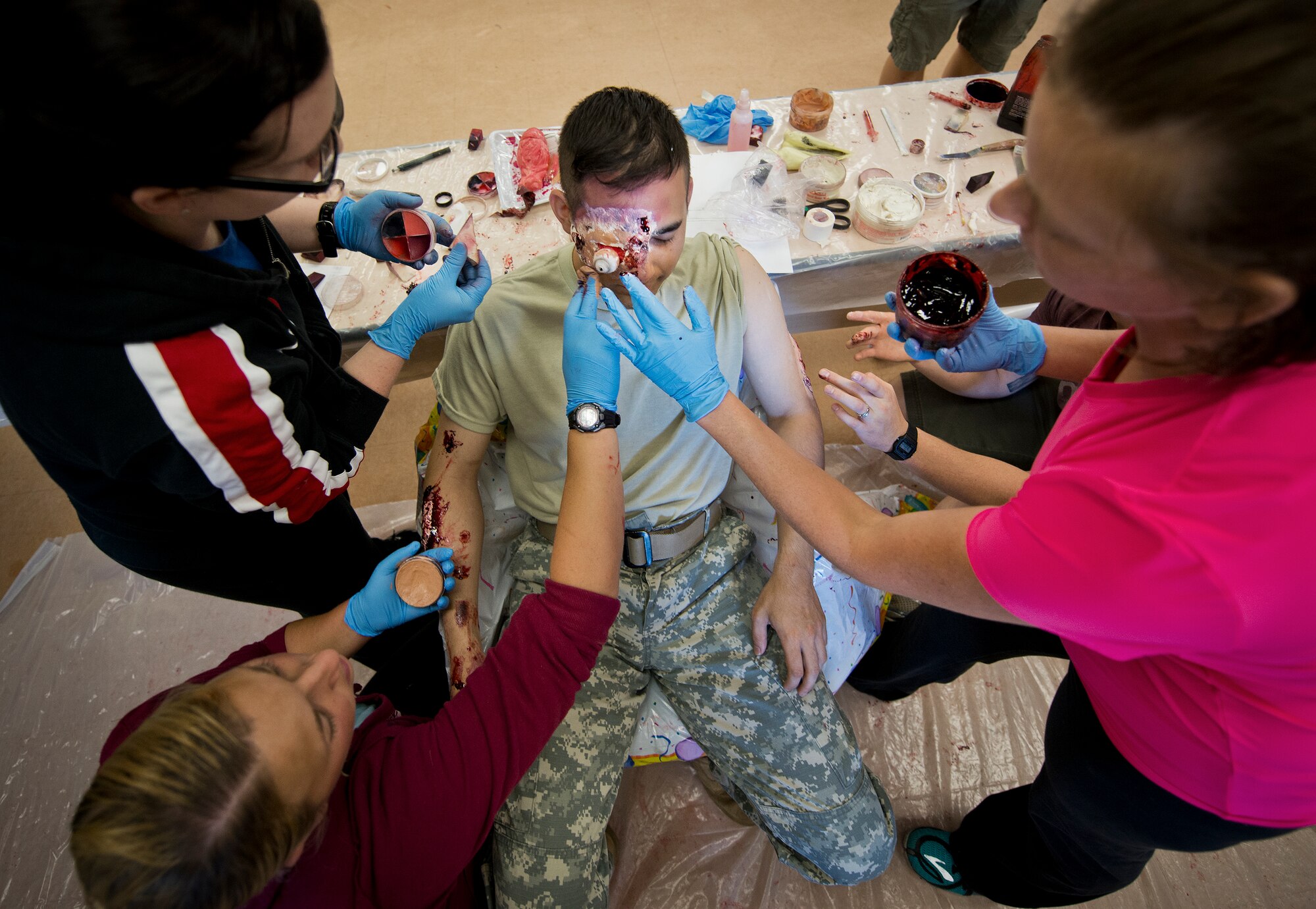 Moulage team members from the 96th Medical Group apply blood, and make up to a simulated victim prior to the annual major accident response exercise at the 6th Ranger Training Battalion Oct. 16 at Eglin Air Force Base, Fla.  The moulage team created simulated injuries to approximately 10 Soldiers to add realism to a boat and helicopter crash scenario.  (U.S. Air Force photo/Samuel King Jr.)