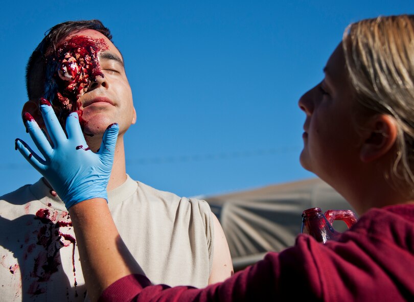 A 96th Medical Group moulage team member applies fake blood to a simulated victim prior to the annual major accident response exercise at the 6th Ranger Training Battalion Oct. 16 at Eglin Air Force Base, Fla.  The moulage team created simulated injuries to approximately 10 Soldiers to add realism to a boat and helicopter crash scenario.  (U.S. Air Force photo/Samuel King Jr.)