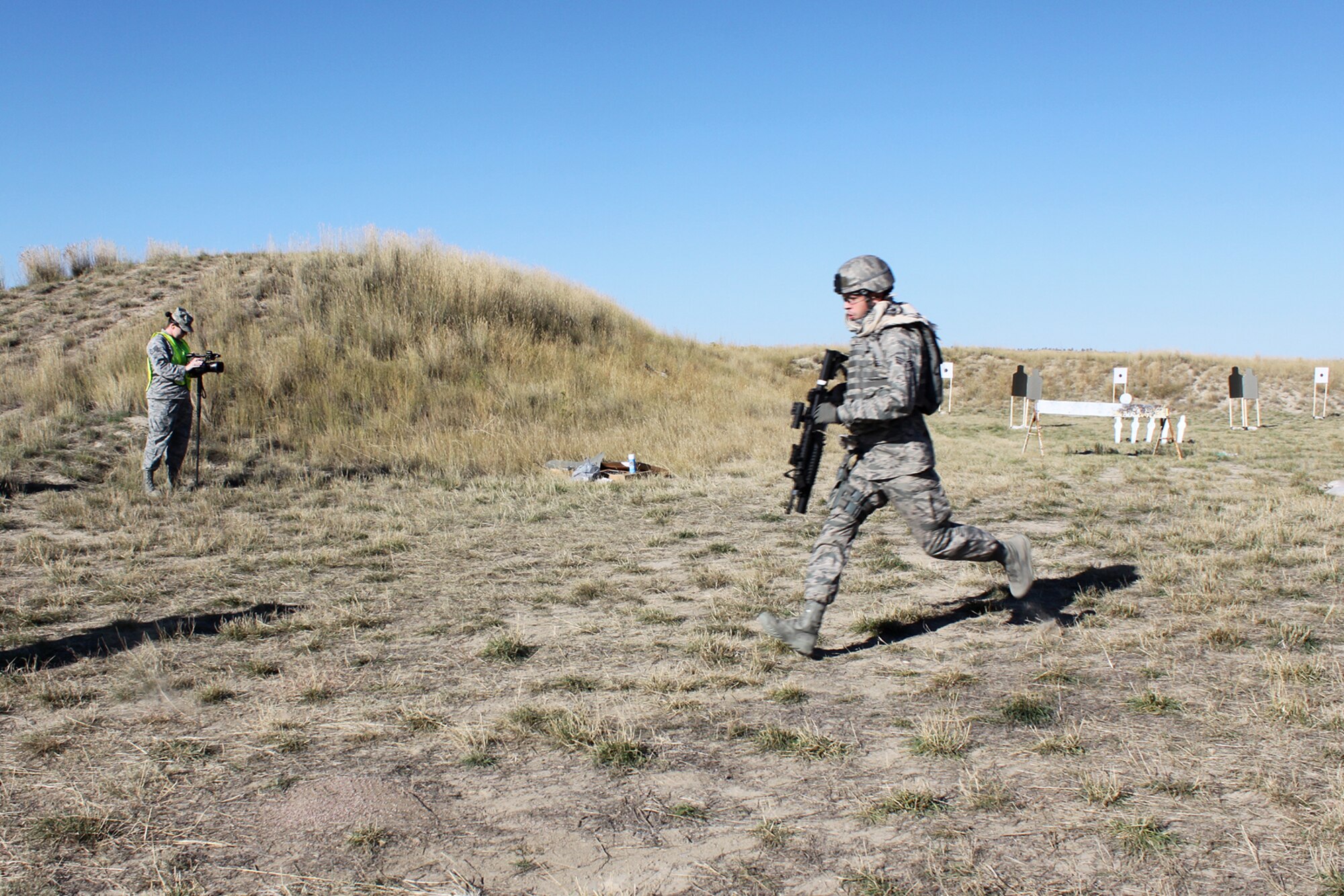U.S. Air Force Senior Airman Clint Melancon runs to the next firing position after completing the M9 pistol firing competition during the Global Strike Challenge, Sept. 24, 2014, Camp Guernsey, Wyo. The Global Strike Challenge is the world's premier bomber, Intercontinental Ballistic Missile, helicopter operations and security forces competition with units from Air Force Global Strike Command, Air Combat Command, Air Force Reserve Command and the Air National Guard. (U.S. Air Force photo by Tech. Sgt. Starlight Lesher/Released)