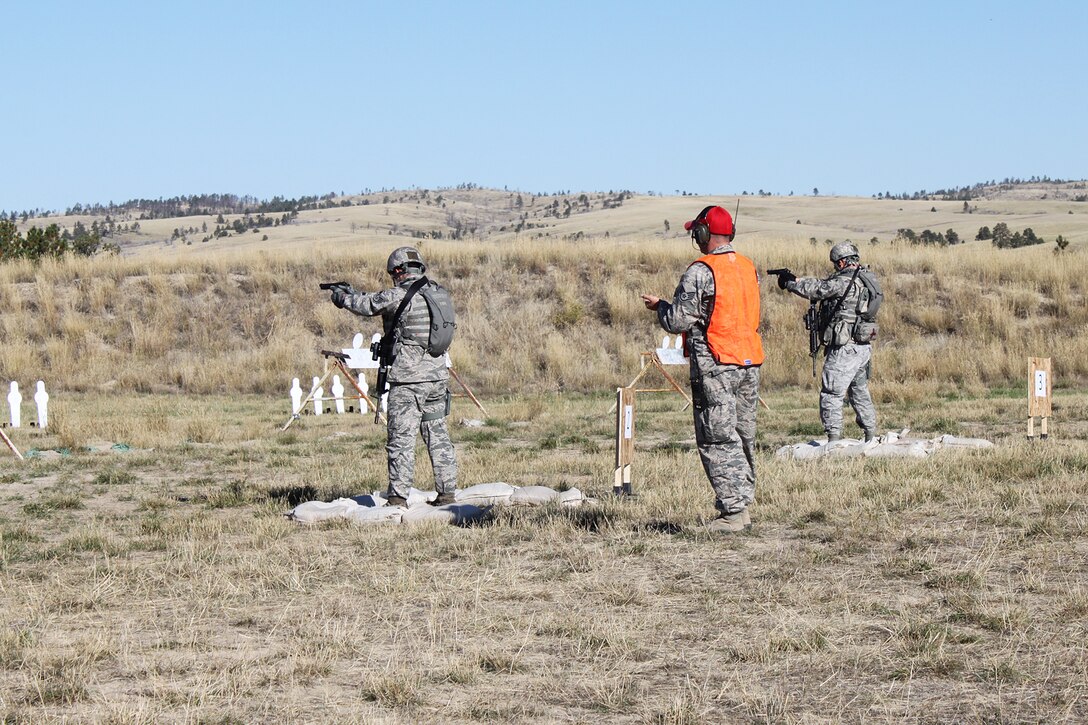 Members of the 307th Security Forces Squadron fire their M9 handgun during the Global Strike Challenge Weapons Firing competition, Sept. 24, 2014, Camp Guernsey, Wyo. The Global Strike Challenge is the world's premier bomber, Intercontinental Ballistic Missile, helicopter operations and security forces competition with units from Air Force Global Strike Command, Air Combat Command, Air Force Reserve Command and the Air National Guard. (U.S. Air Force photo by Tech. Sgt. Starlight Lesher/Released)