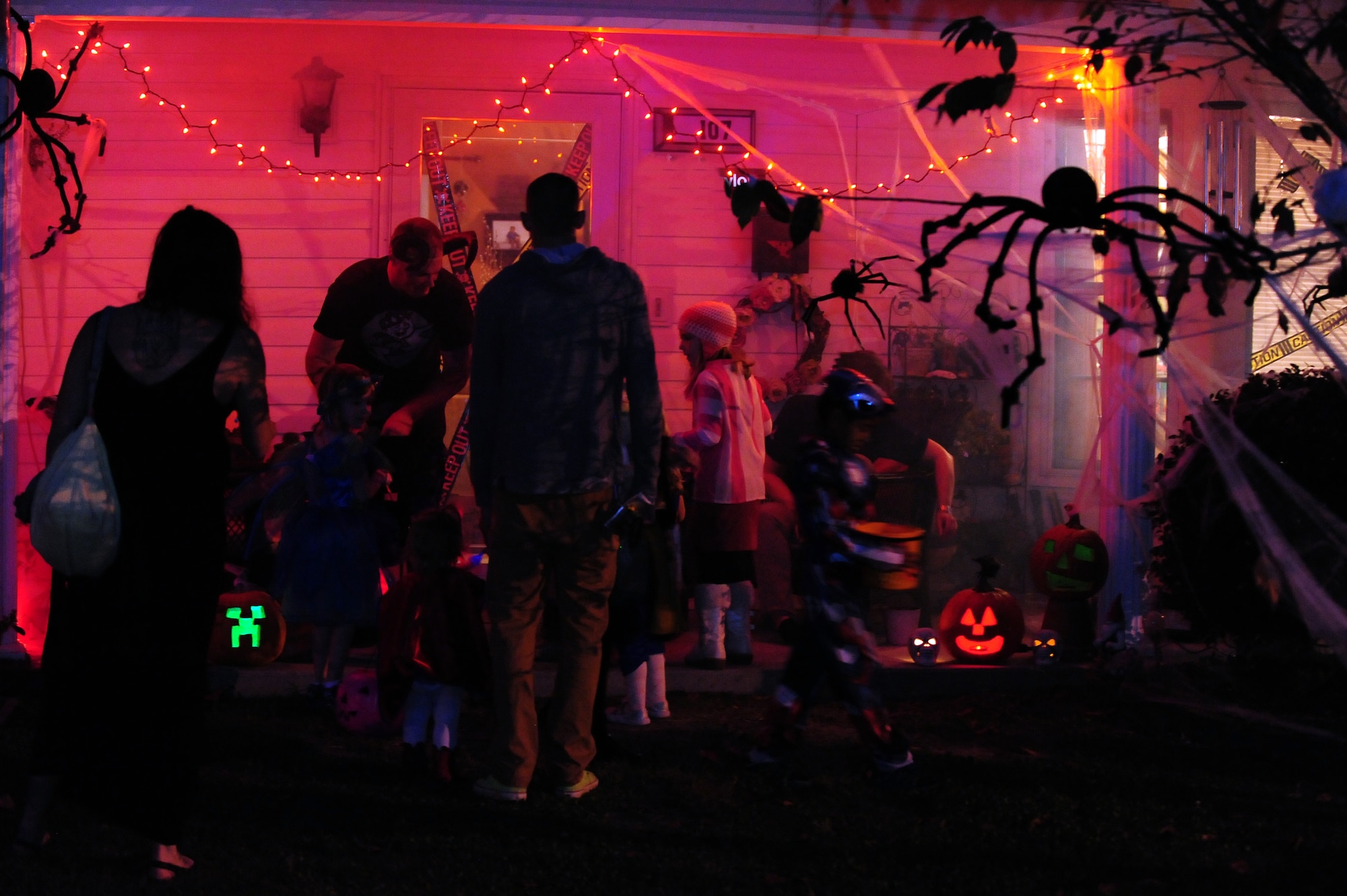 Members of Team Seymour visit the house of U.S. Air Force Staff Sgt. Aaron Taylor, 4th Equipment Maintenance Squadron munitions systems technician, during trick-or-treating at Seymour Johnson Air Force Base, N.C., Oct. 31, 2013. Taylor’s house had multiple special effects for visitors to enjoy, including a fog machine, strobe lights and glowing pumpkins. (U.S. Air Force photo by Airman 1st Class Brittain Crolley/Released)