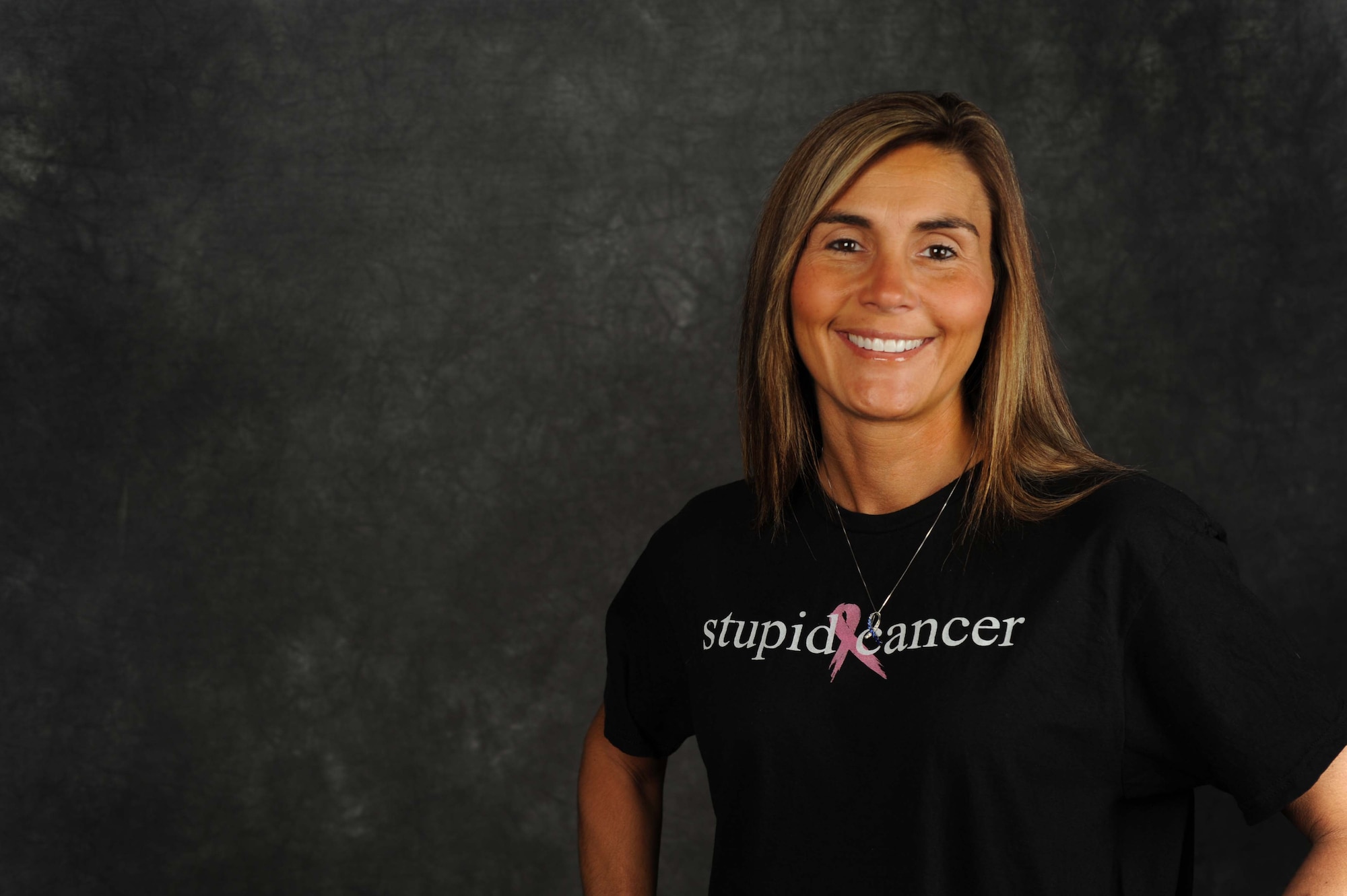 Michelle Betz, 5th Bomb Wing housing management assistant and breast cancer survivor, poses for a photograph on Minot Air Force Base, N.D., Oct. 14, 2014. Betz dedicates the majority of her time to advocating for breast cancer awareness. (U.S. Air Force photo/Airman 1st Class Lauren Pitts) 