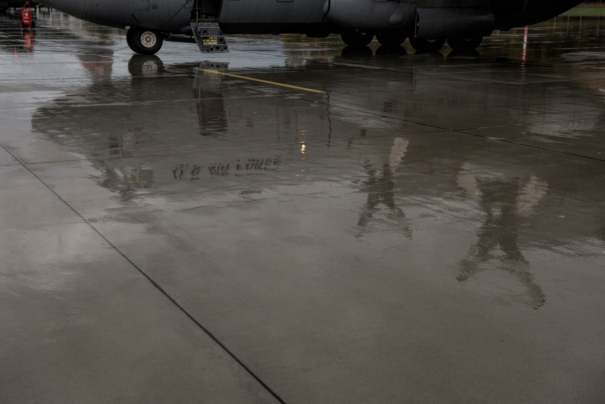 The image of a C-130 Hercules cargo aircraft assigned to the 182nd Airlift Wing, Illinois Air National Guard, Peoria, Ill., is reflected on rain water at Powidz Air Base, Poland, Oct. 20, 2014. The U.S. Air Force Aviation Detachment, 52nd Operations Group, at Lask Air Base, Poland, hosted the 182nd AW during bilateral training with the Polish air force. (U.S. Air Force photo by Staff Sgt. Christopher Ruano/Released)