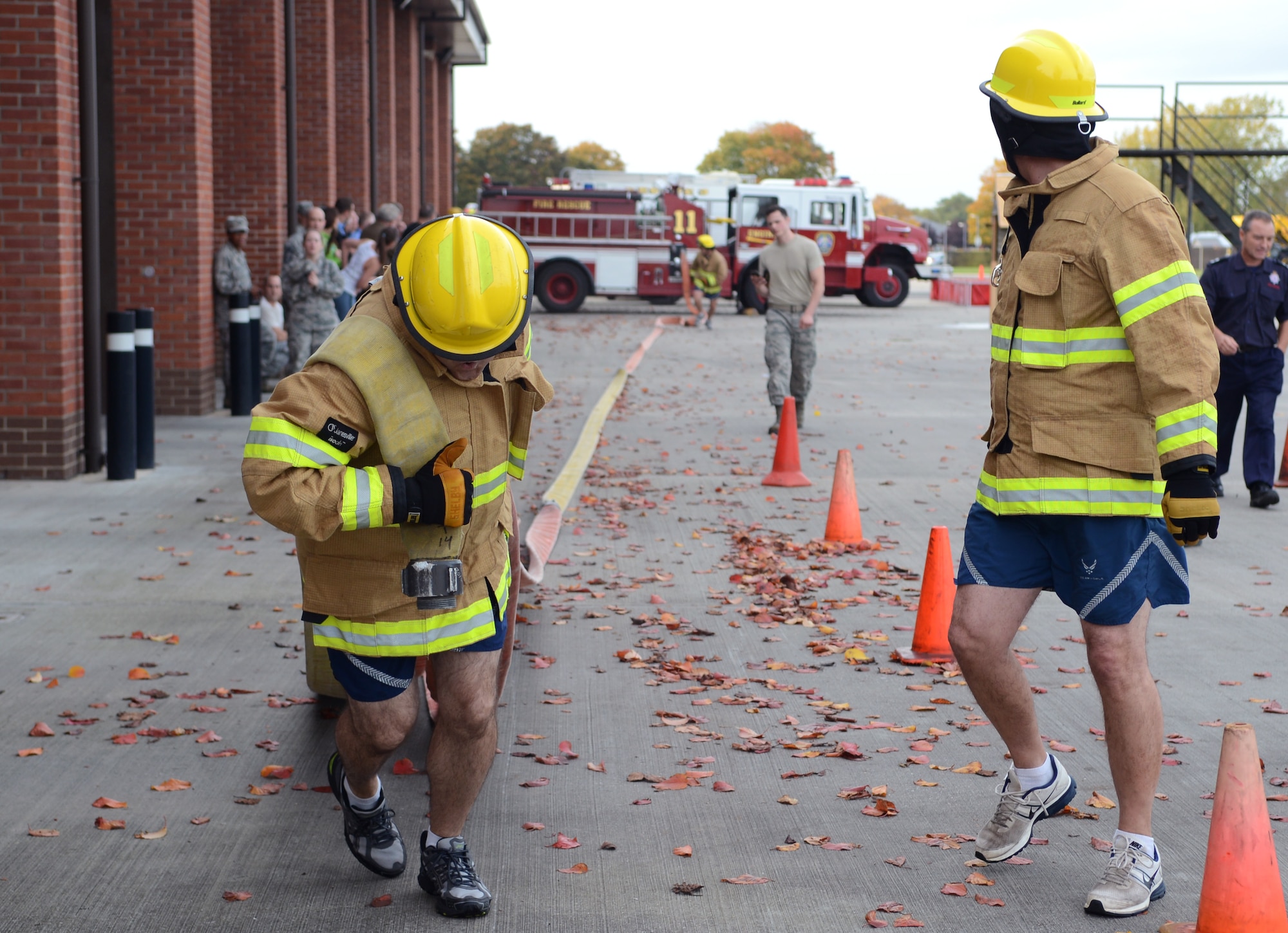 U.S. Air Force Chief Master Sgt. Brian Schexnider, left, 100th Logistics Readiness Squadron fuels manager, pulls a fire hose Oct. 17, 2014, during the Fire Prevention Week “Chiefs versus Eagles” fire muster on RAF Mildenhall, England. The muster was the capstone event for Fire Prevention Week, and drew in teams from squadrons across base. (U.S. Air Force photo/Airman 1st Class Dillon Johnston/Released)