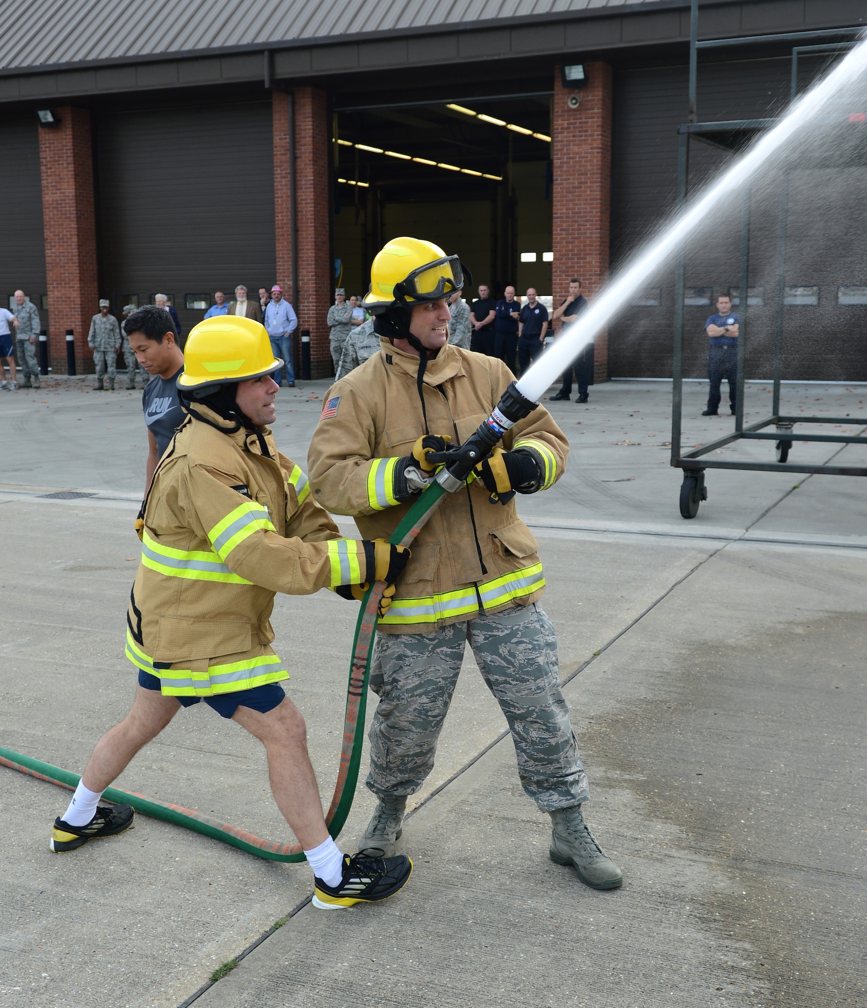 U.S. Air Force Lt. Col. Albert Frank, left, 100th Mission Support Group deputy commander, and U.S. Air Force Col. David Cox, 100th Air Refueling Wing vice commander, spray water from a hose Oct. 17, 2014, during the Fire Prevention Week “Chiefs versus Eagles” fire muster on RAF Mildenhall, England. The muster was the capstone event for Fire Prevention Week, and drew in teams from squadrons across base. (U.S. Air Force photo/Airman 1st Class Dillon Johnston/Released)