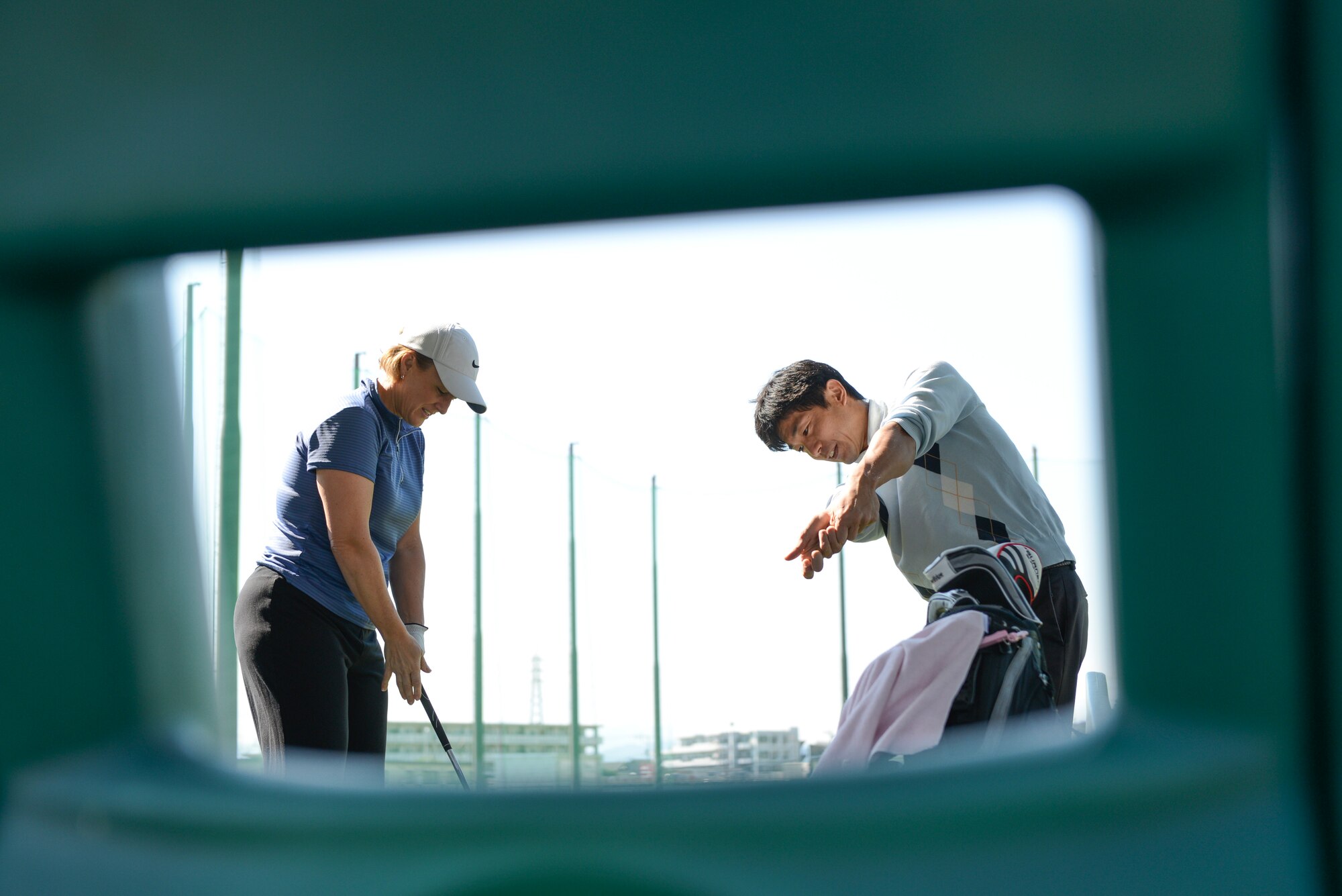Tomoaki Kibamoto, Par 3 Golf Course instructor, shows Angel, wife of David Mansberger, a proper golf swing technique during a Free Golf Clinic at Yokota Air Base, Japan, Oct. 18, 2014. Kibamoto hosts the free clinic every Saturday to assist Yokota community members in improving their golf games. (U.S. Air Force photo by Staff Sgt. Cody H. Ramirez/Released)