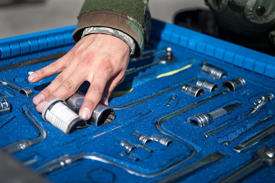 Senior Airman Miguel Acosta, 8th Aircraft Maintenance Squadron 80th Aircraft Maintenance Unit weapons load crew member, Kunsan Air Base, Republic of Korea, puts tools away during a quarterly load crew competition at Osan Air Base, ROK, Oct. 17, 2014. In addition to the weapons loading, crews are also inspected on their dress and appearance and their tool boxes inspected for good order. (U.S. Air Force photo by Senior Airman Matthew Lancaster)