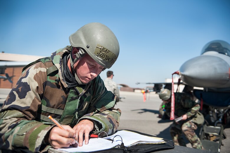 Senior Airman Justin Torrey, 8th Aircraft Maintenance Squadron 80th Aircraft Maintenance Unit, Kunsan Air Base, Republic of Korea, fills out aircraft forms during a quarterly load crew competition at Osan Air Base, ROK, Oct. 17, 2014. Load crew members are evaluated on their safety, speed, and use of the checklist. (U.S. Air Force photo by Senior Airman Matthew Lancaster)