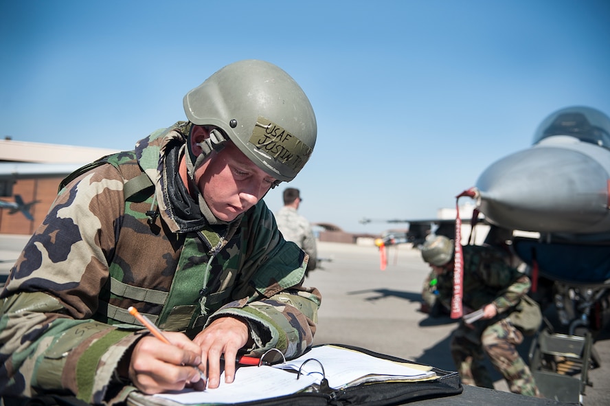 Senior Airman Justin Torrey, 8th Aircraft Maintenance Squadron 80th Aircraft Maintenance Unit, Kunsan Air Base, Republic of Korea, fills out aircraft forms during a quarterly load crew competition at Osan Air Base, ROK, Oct. 17, 2014. Load crew members are evaluated on their safety, speed, and use of the checklist. (U.S. Air Force photo by Senior Airman Matthew Lancaster)