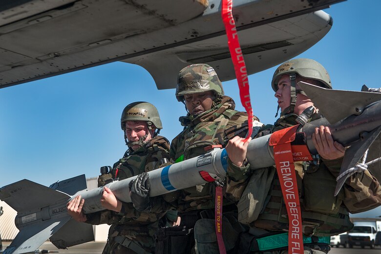 Senior Airman Benjamin Lilley, Staff Sgt. Kenneth Nelems, and Senior Airman Hunter Rivera, all 51st Aircraft Maintenance Squadron 25th AMU weapons load crew members, load an Air Intercept Missile-9M Sidewinder air-to-air missile onto an A-10 Thunderbolt II during a quarterly load crew competition at Osan Air Base, Republic of Korea, Oct. 17, 2014. Load crew competitions promote a safe competitive environment where Airmen display their skills and ability to apply their training. (U.S. Air Force photo by Senior Airman Matthew Lancaster)
