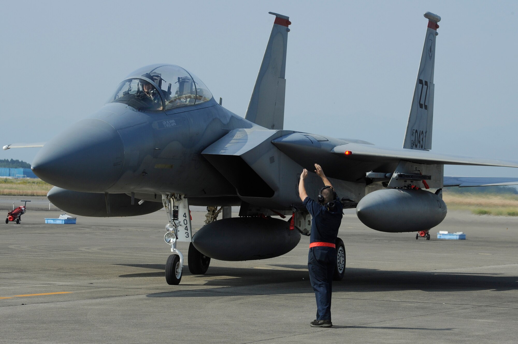 U.S. Air Force Airman 1st Class Michael Luis, 67th Aircraft Maintenance Unit crew chief, marshals an F-15 Eagle into position on Nyutabaru Air Base, Japan, Oct. 18, 2014. Twelve F-15s arrived from Kadena Air Base, Japan, to participate in a two week-long Aviation Training Relocation Program. (U.S. Air Force photo by Senior Airman Marcus Morris/Released)