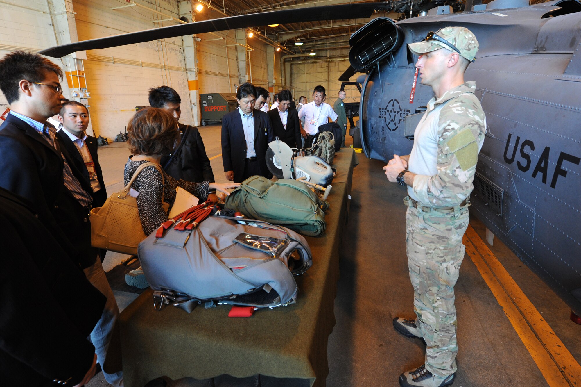 U.S. Air Force Tech. Sgt. Gregory Gibbs, 33rd Rescue Squadron pararescueman, briefs 69 local young business executives about his job and the gear they use at the 33rd RQS on Kadena Air Base, Okinawa, Japan, Oct. 17, 2014. The group toured the 33rd RQS to gain a better understanding of their mission and their capabilities. (U.S. Air Force photo by Airmen 1st Class Stephen G. Eigel/Released) 