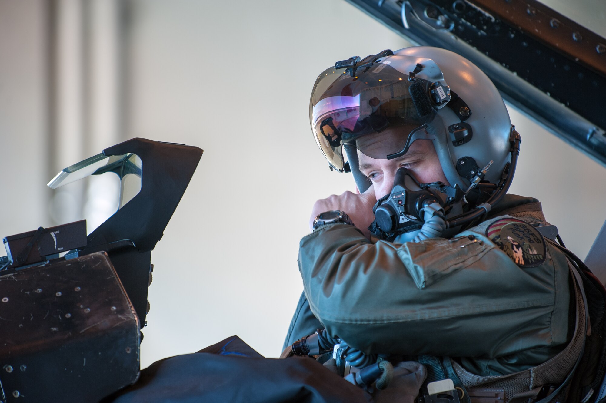 1st Lt. Jared Tew, 35th Fighter Squadron pilot, puts on his helmet before taxiing during RED FLAG-Alaska 15-1 at Eielson Air Base, Oct. 16, 2014. This field training exercise is focused on improving the combat readiness of U.S. and international forces and providing training for units preparing for air expeditionary force tasking. (U.S. Air Force Photo by Senior Airman Taylor Curry/Released)